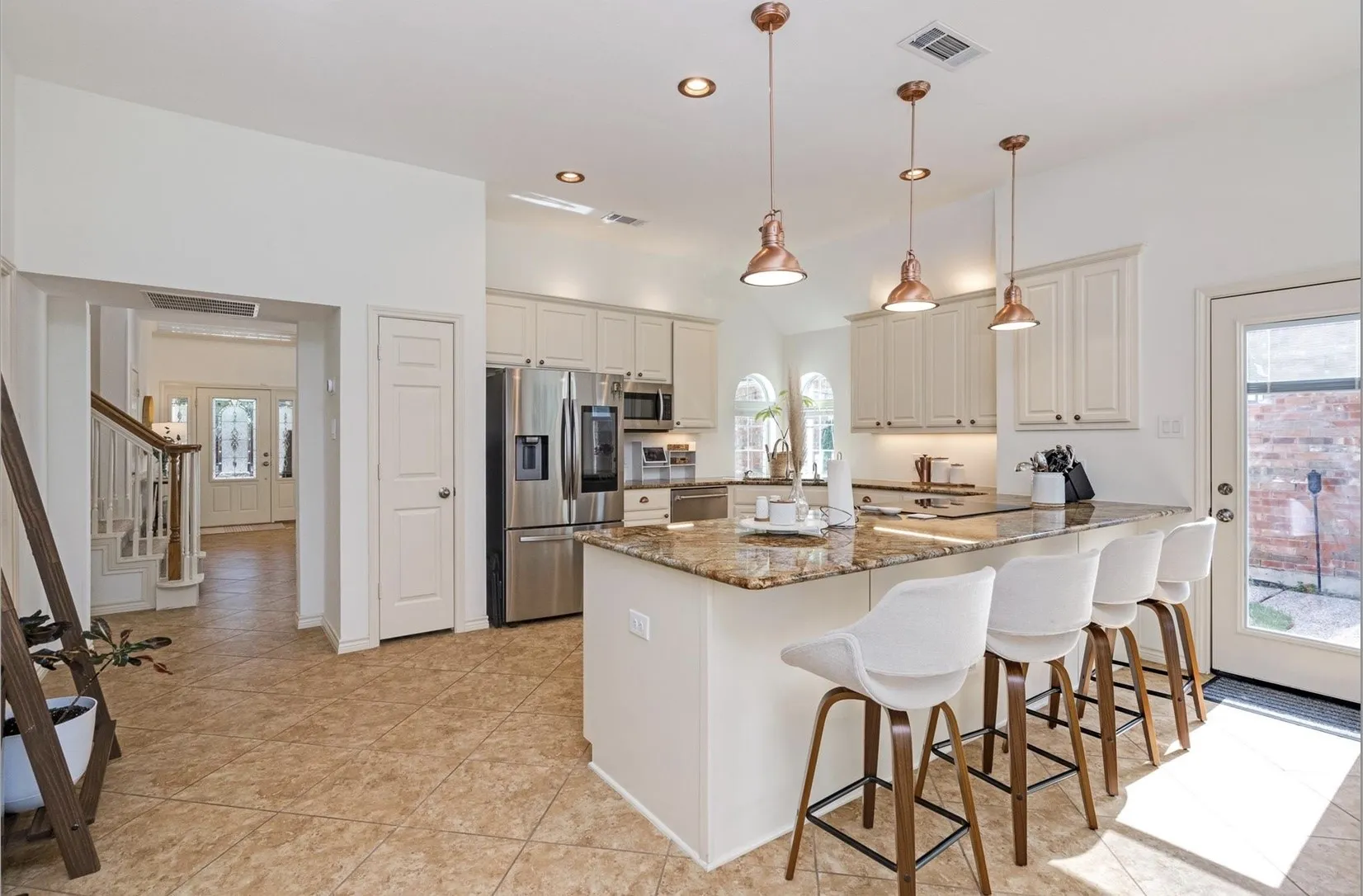 Kitchen with granite-style countertops, stainless steel appliances, recessed lighting, and warm-toned pendant fixtures