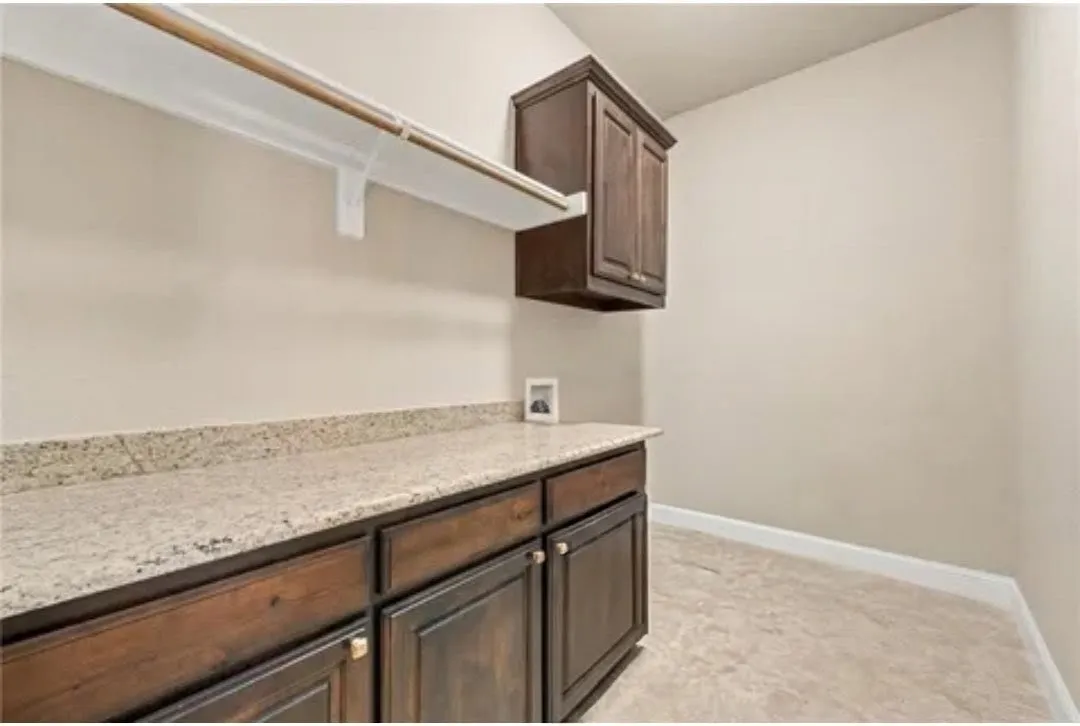 Built-in cabinetry with bronze hardware, a light-toned countertop, and tile flooring