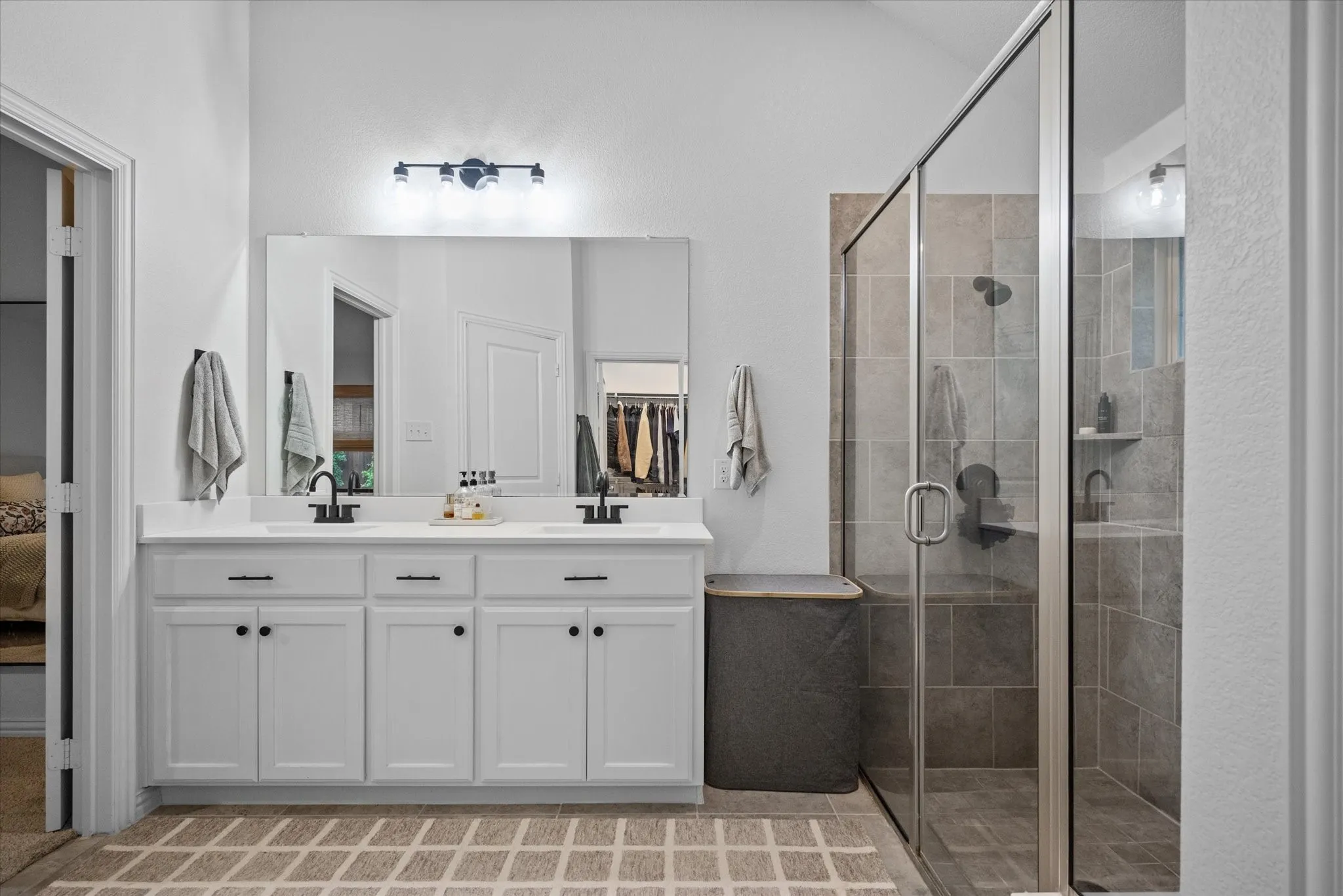 Dual vanity with white cabinetry, quartz countertop, and black fixtures