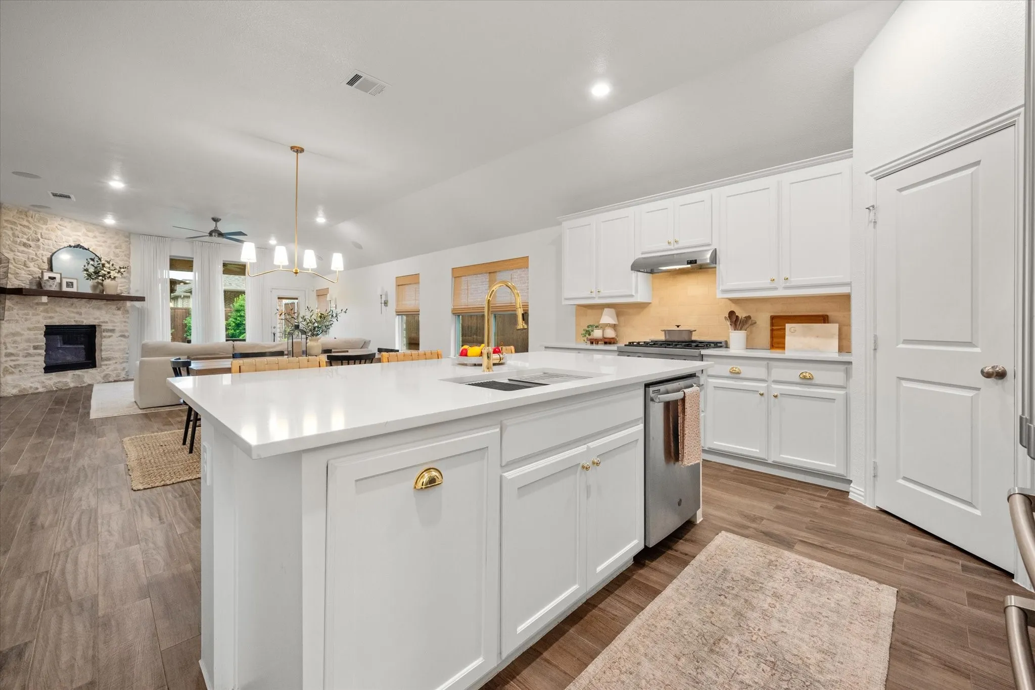 Kitchen island with white countertops, white cabinetry, and gold-tone hardware
