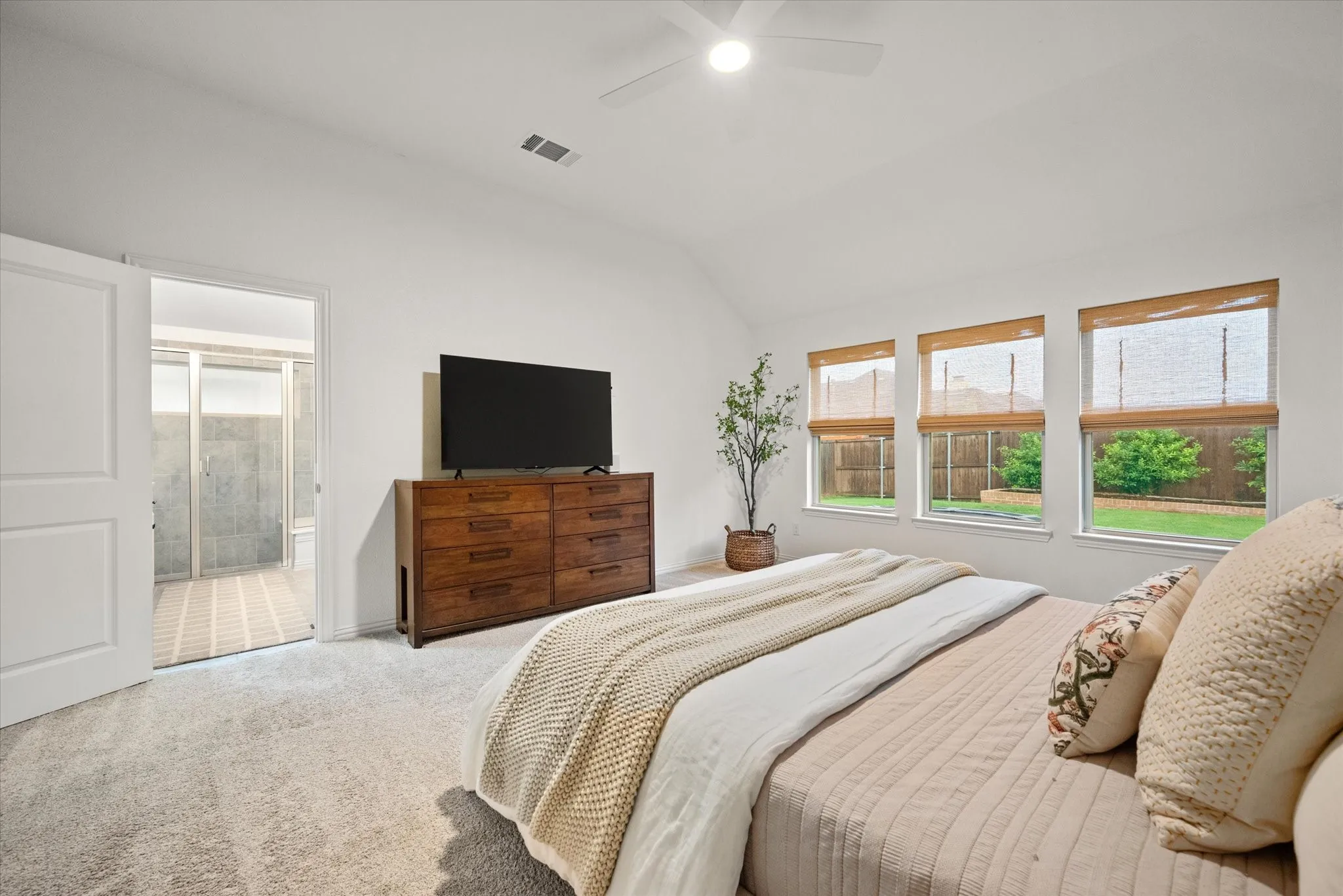 Recessed ceiling with a flush-mount light fixture, three windows with natural light, and soft carpeting