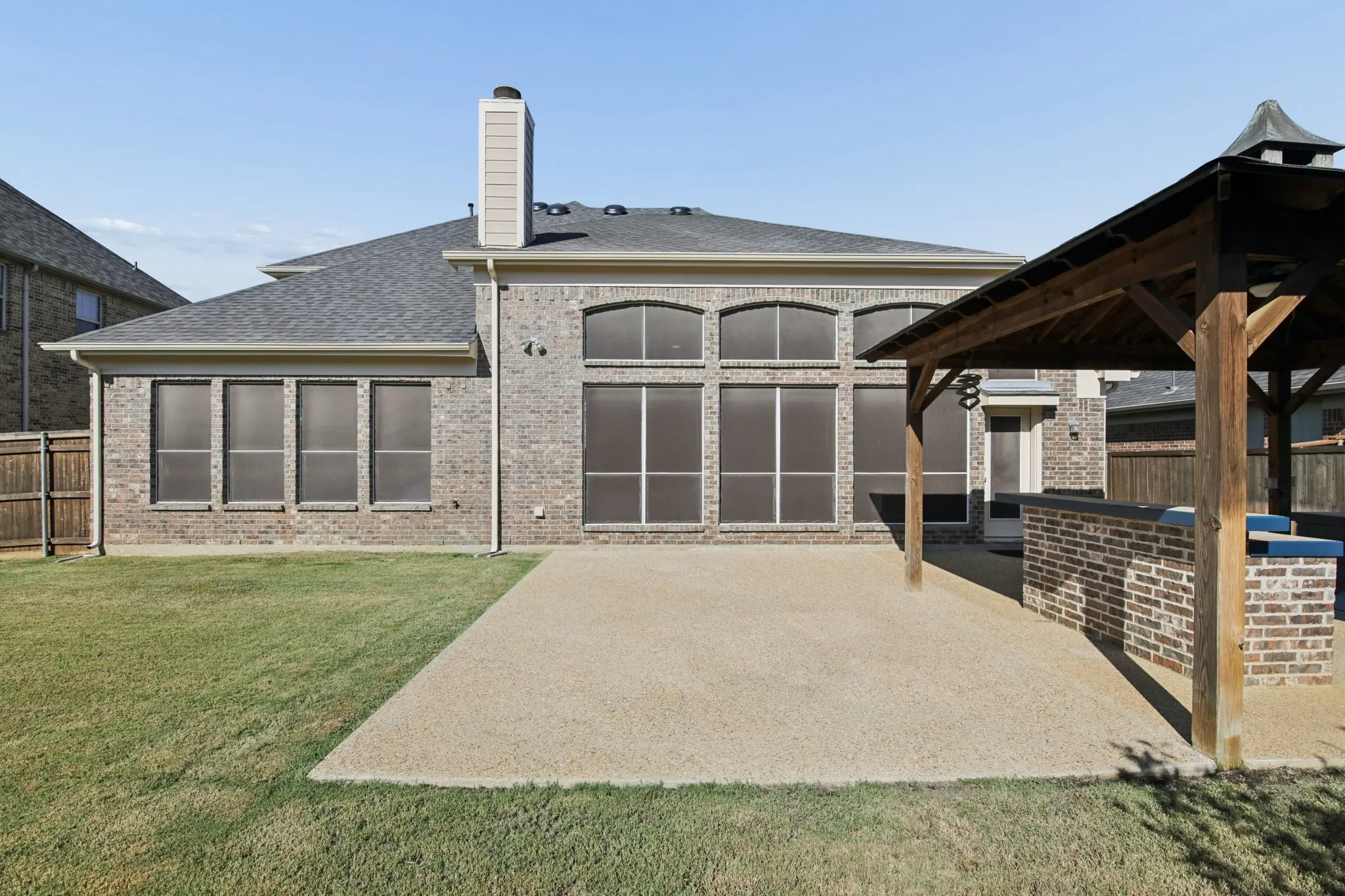 Expansive brick exterior with multiple windows and a prominent chimney