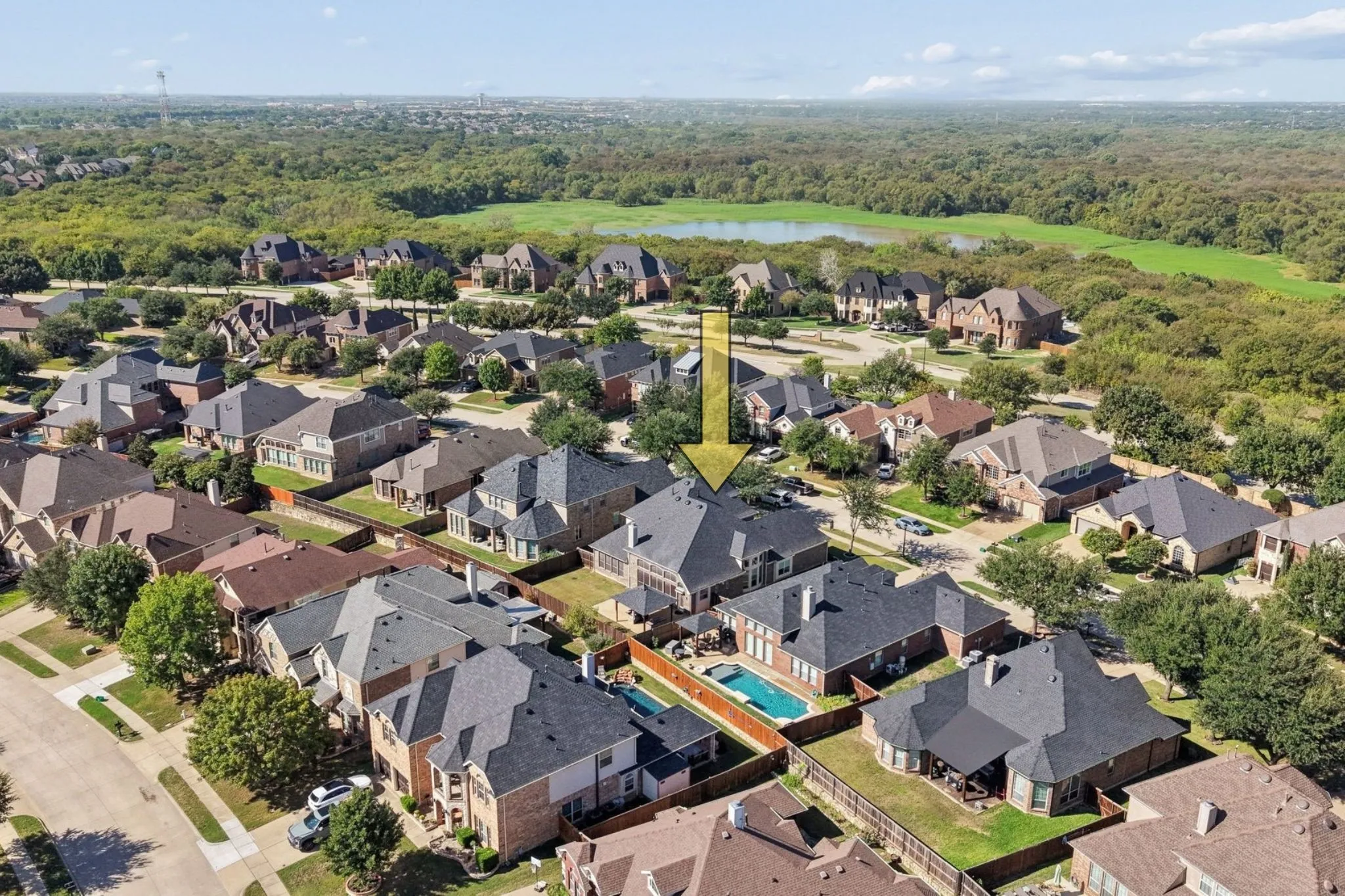 Expansive residential neighborhood with mature trees, a community lake, and a private pool