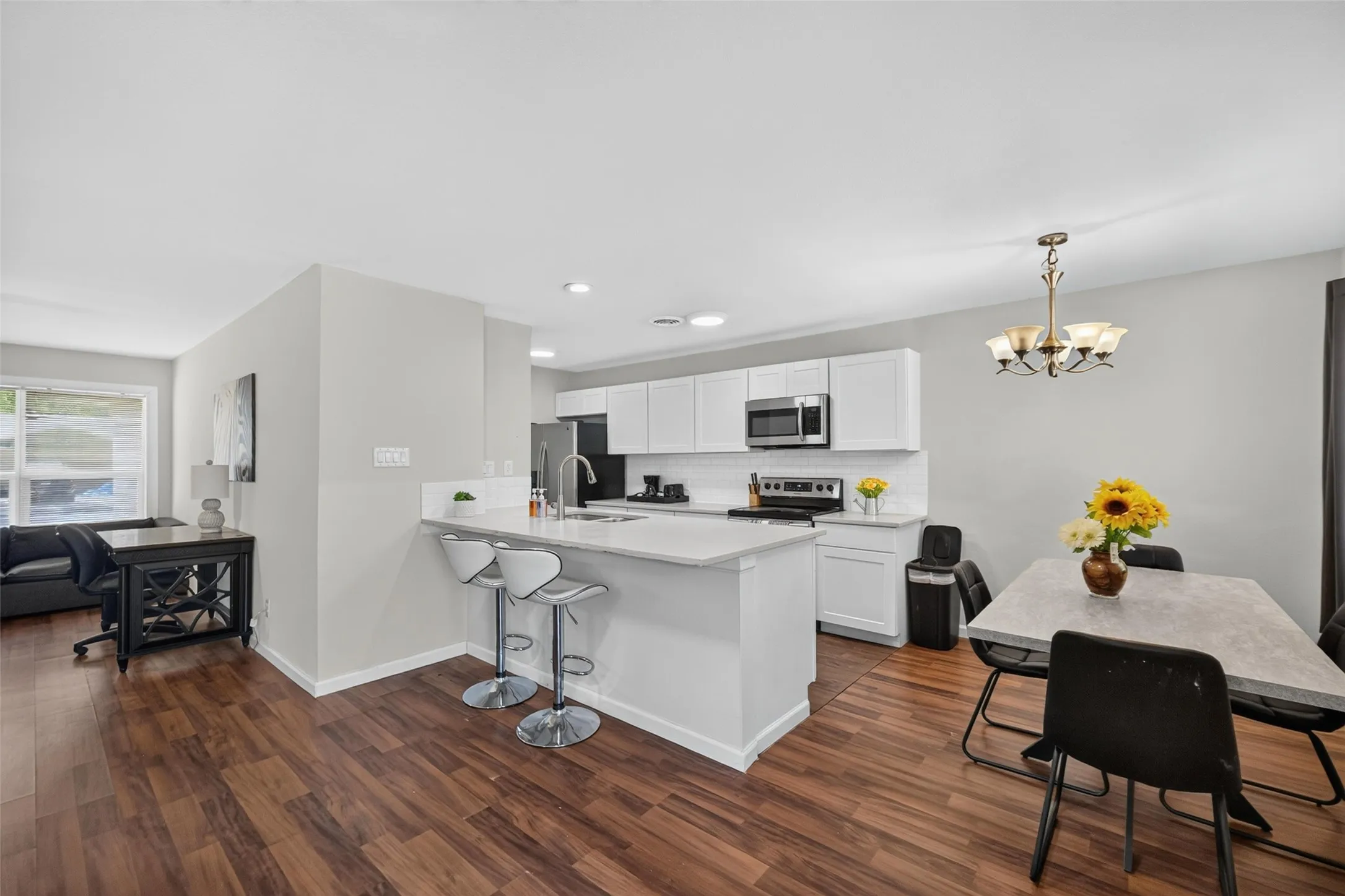 Kitchen with white cabinetry, stainless steel appliances, and a breakfast bar