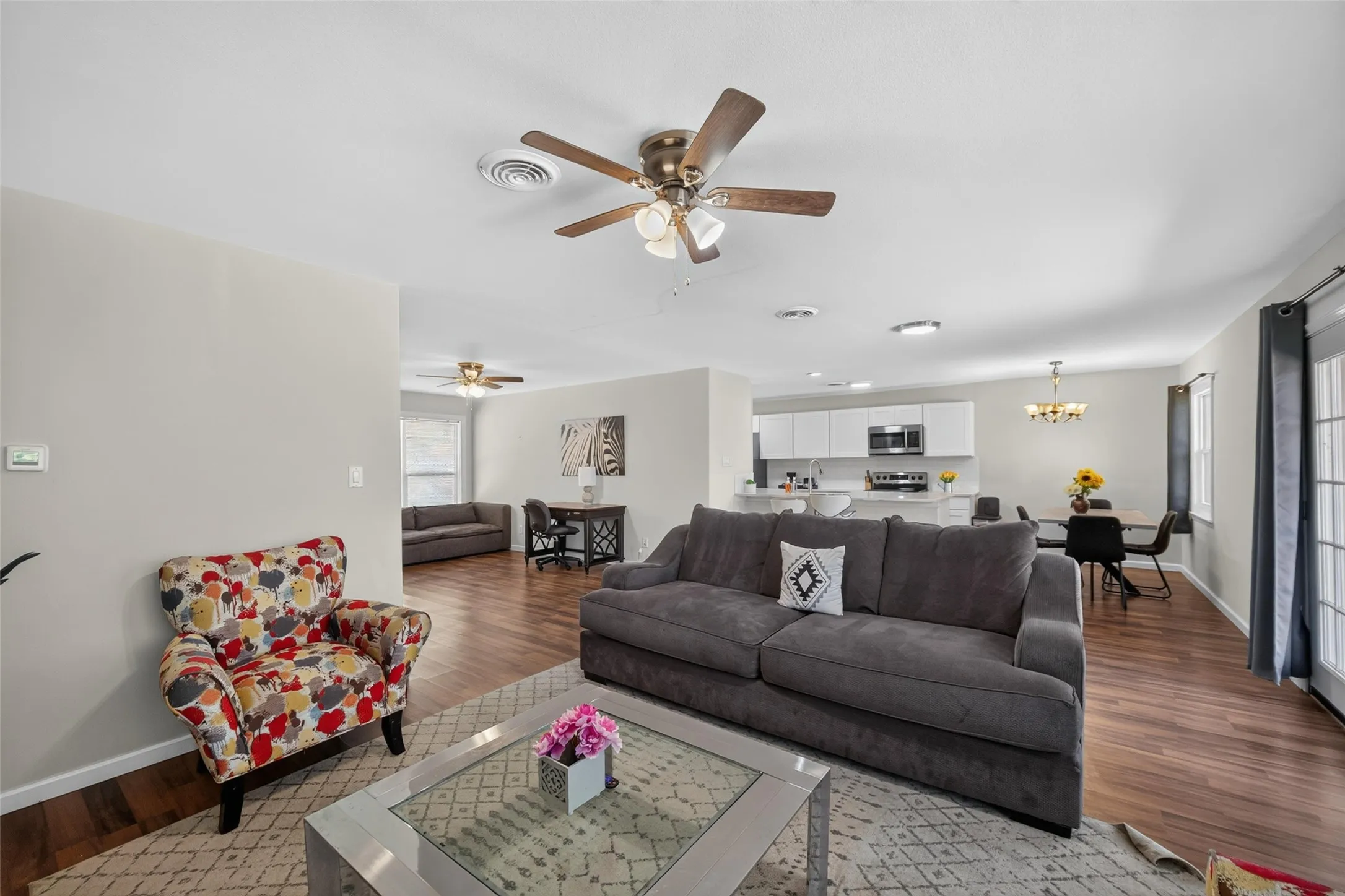 Open-concept living area featuring wood-finish flooring, recessed lighting, and a ceiling fan