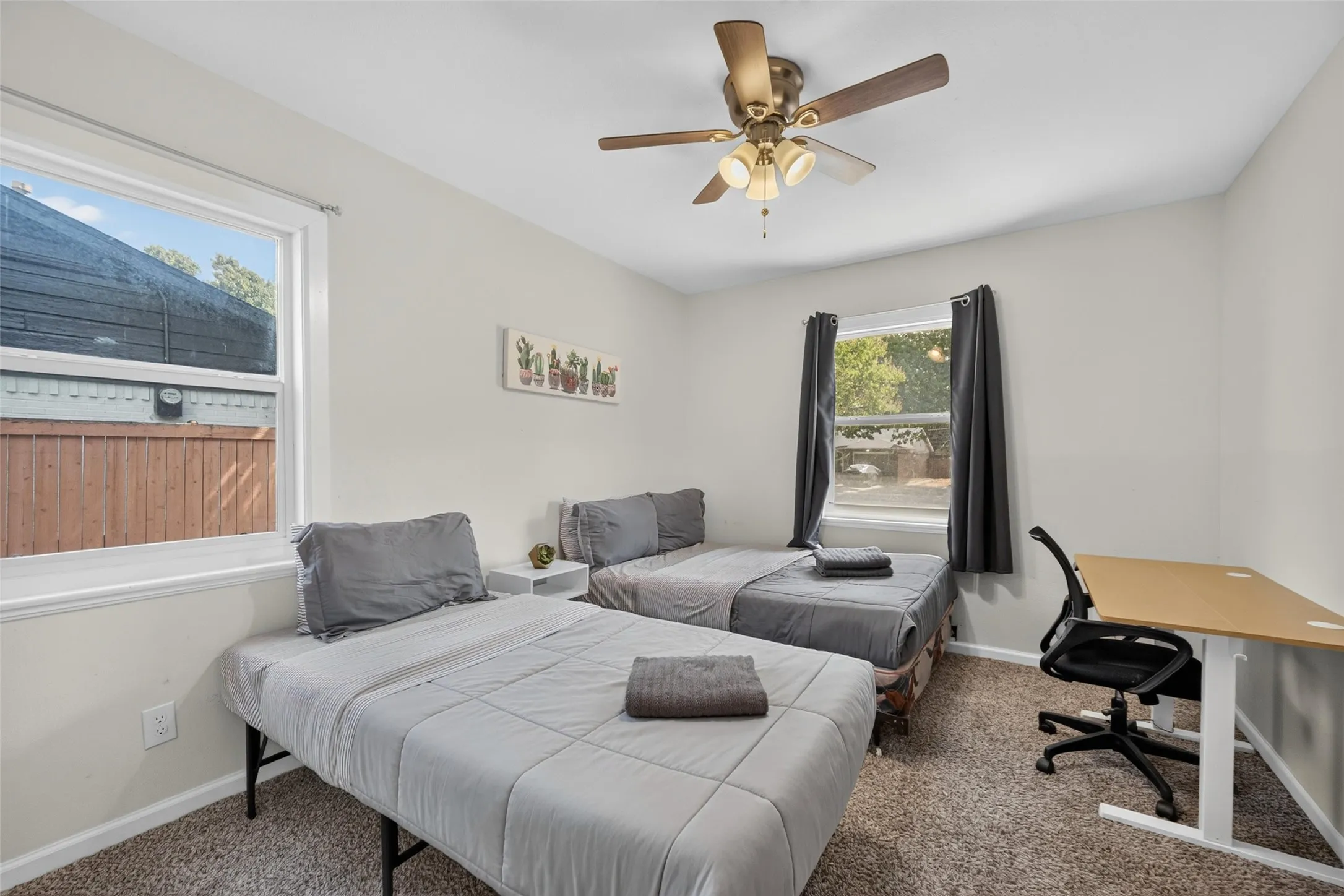 Double windows provide ample natural light, complemented by a ceiling fan with integrated lighting