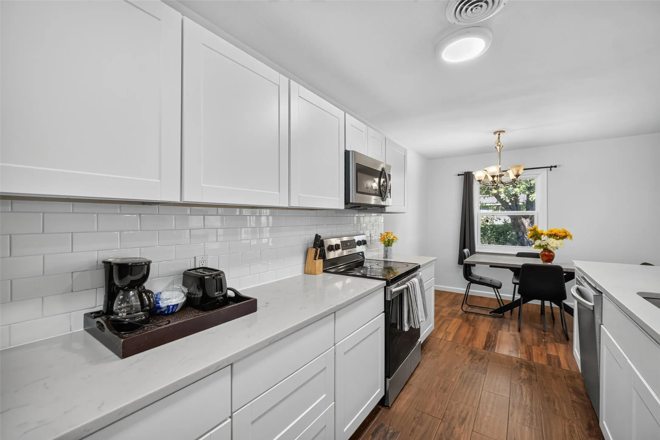 White shaker-style cabinetry, subway tile backsplash, and light-toned countertops