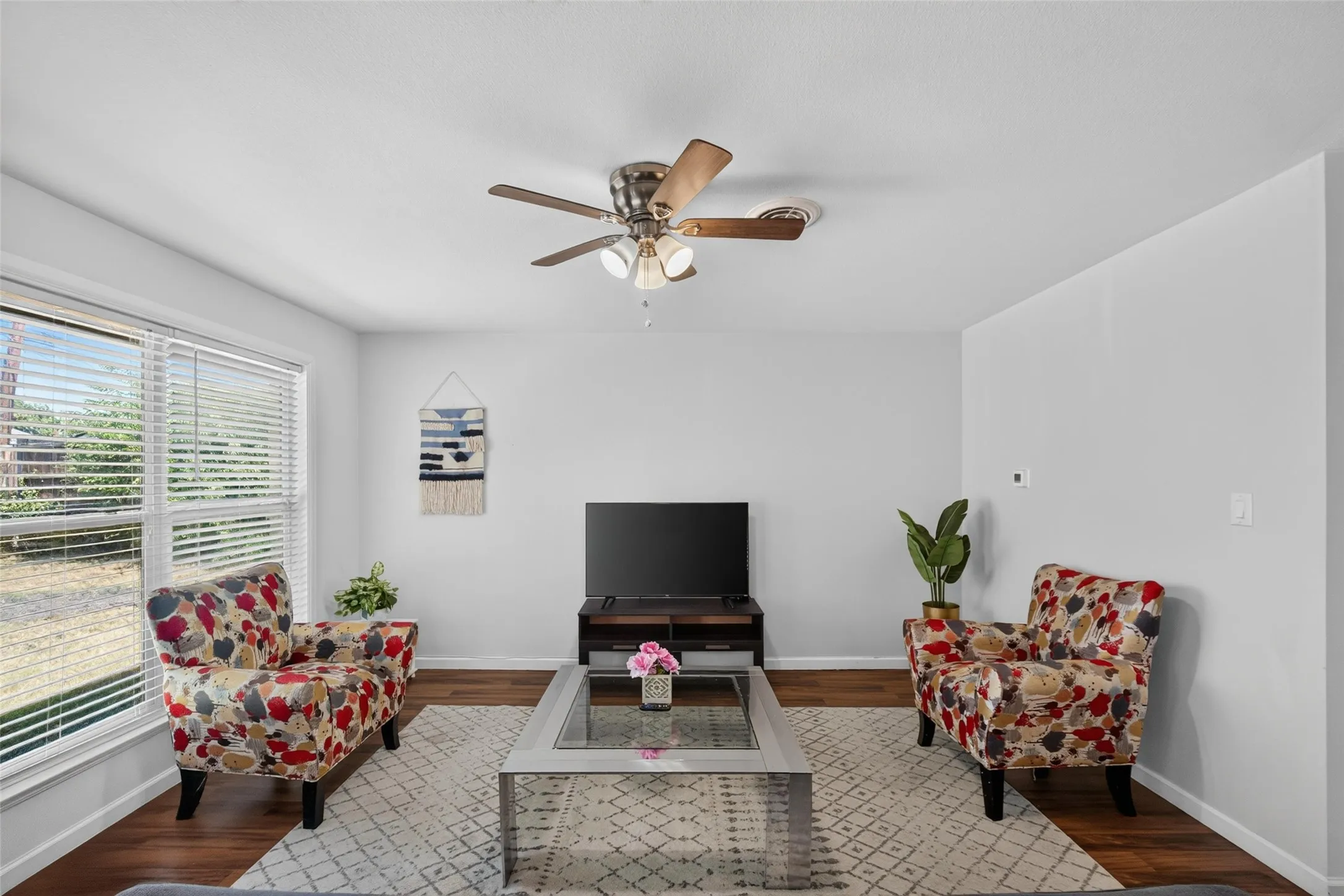 Recessed lighting, wood-finish flooring, and a ceiling fan with integrated lighting