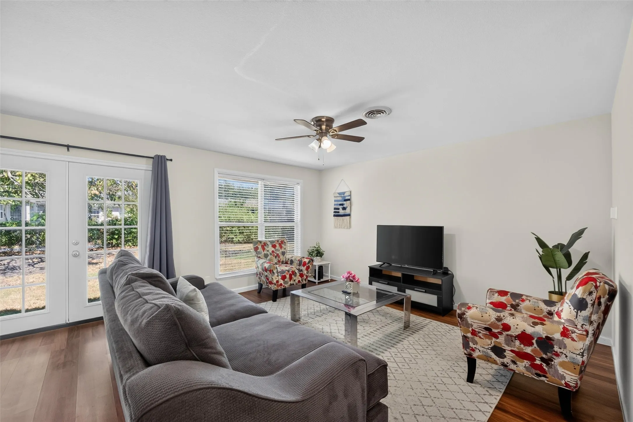 Wood-finish flooring throughout, with a ceiling fan featuring integrated lighting