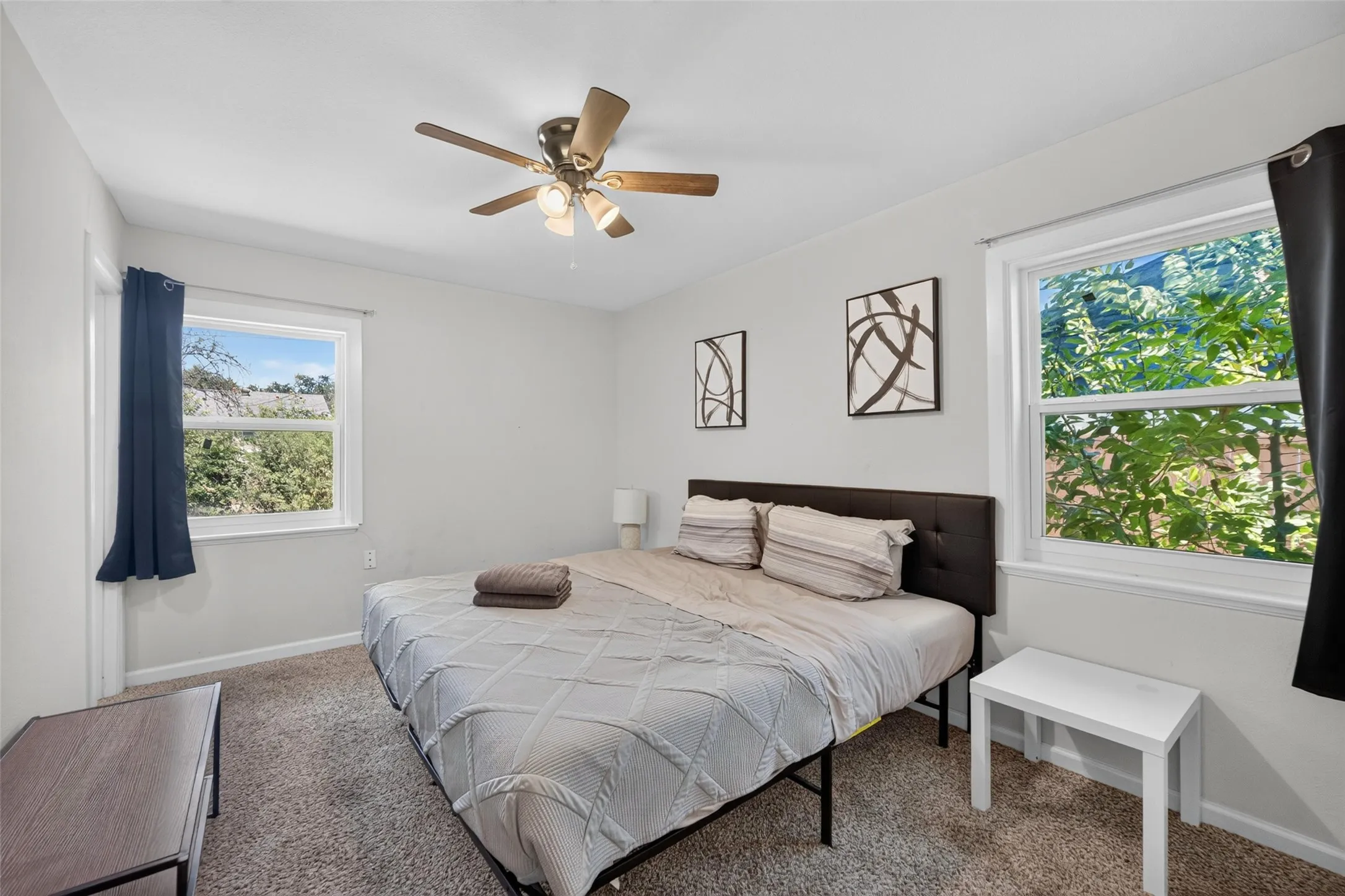 White walls, two windows, and a ceiling fan