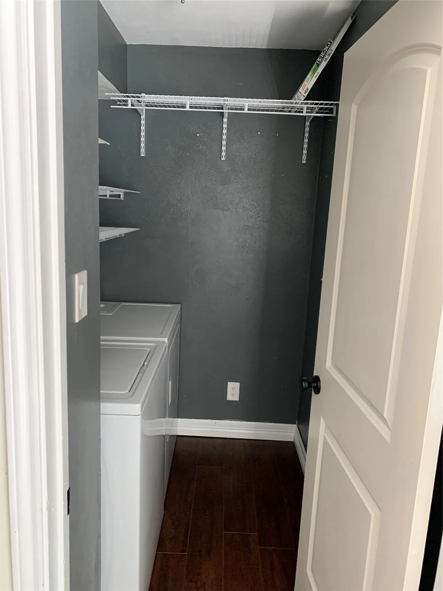 Clothes washing area with dark hardwood / wood-style flooring and independent washer and dryer