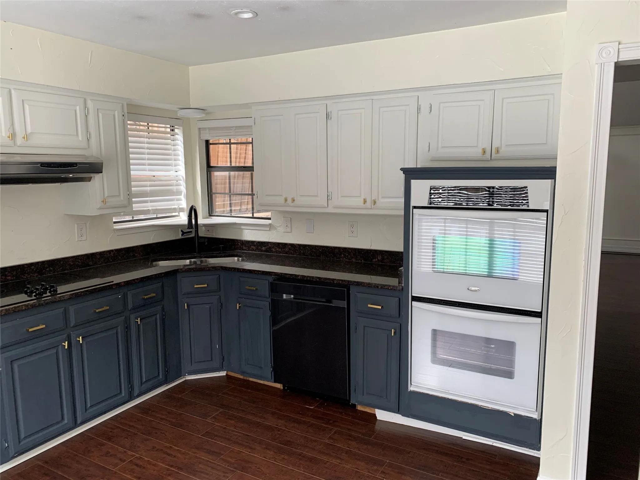 Kitchen featuring white cabinetry, dark hardwood / wood-style floors, sink, and black appliances