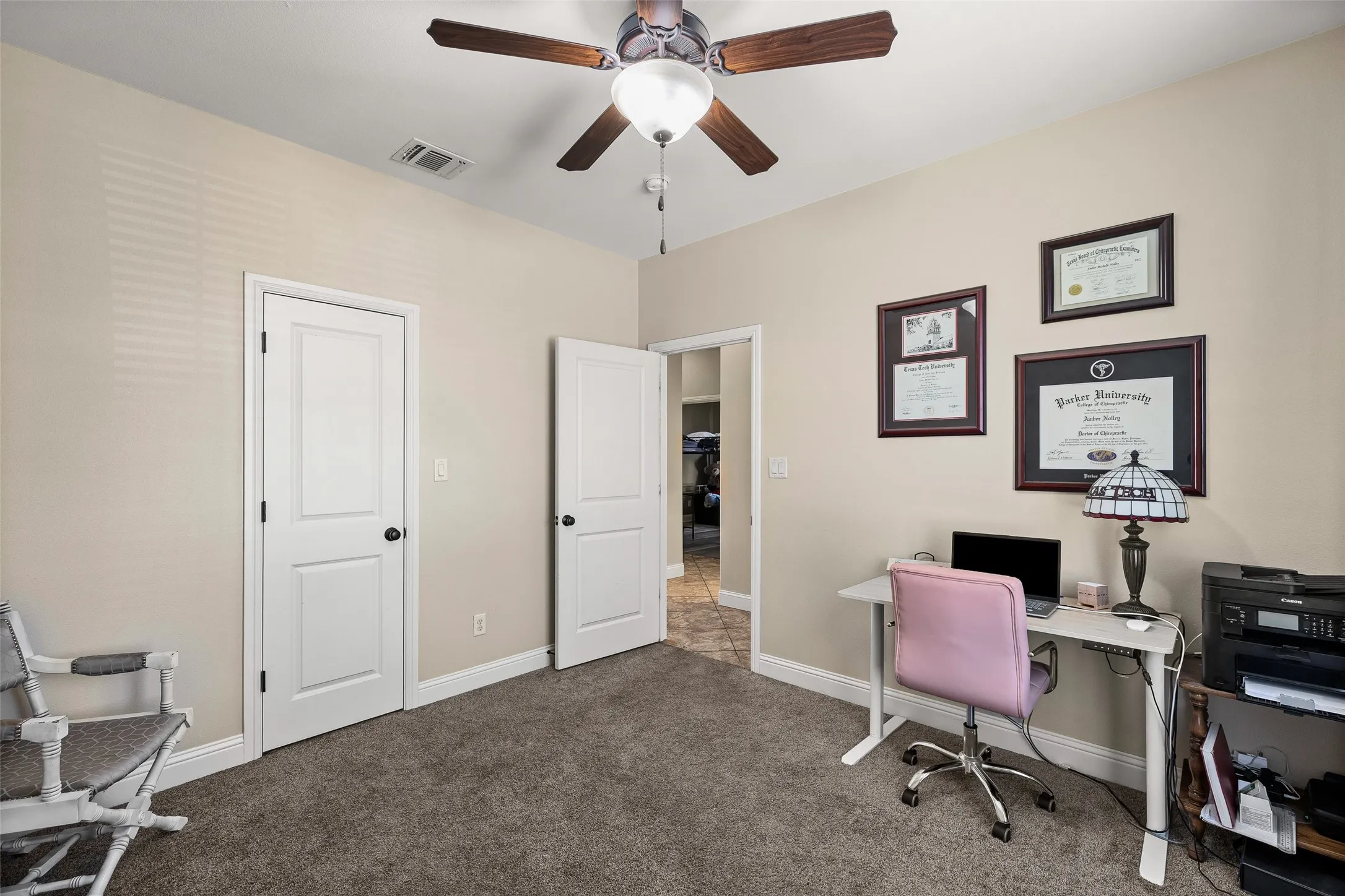 Recessed lighting, ceiling fan with wood-finish blades, and neutral-toned carpeting
