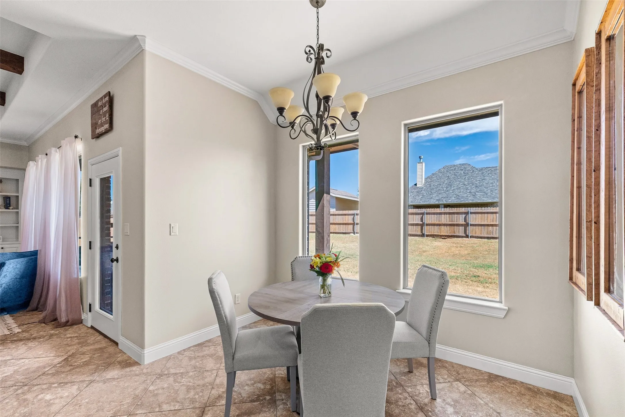 Tiled flooring with a diamond pattern, crown molding, a built-in light fixture, and two large windows