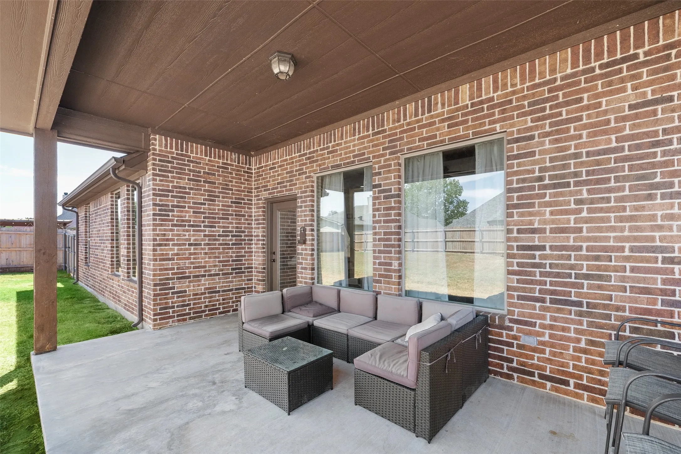Covered patio featuring a concrete slab and brick exterior