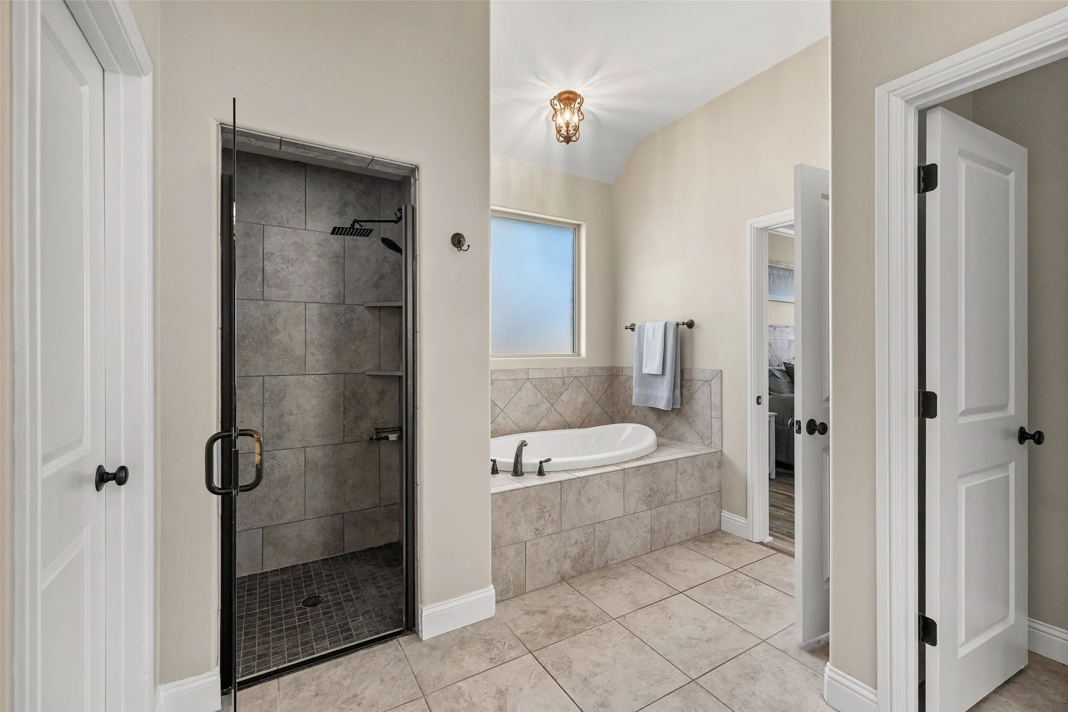 Tiled walk-in shower with clear glass enclosure and rainfall showerhead