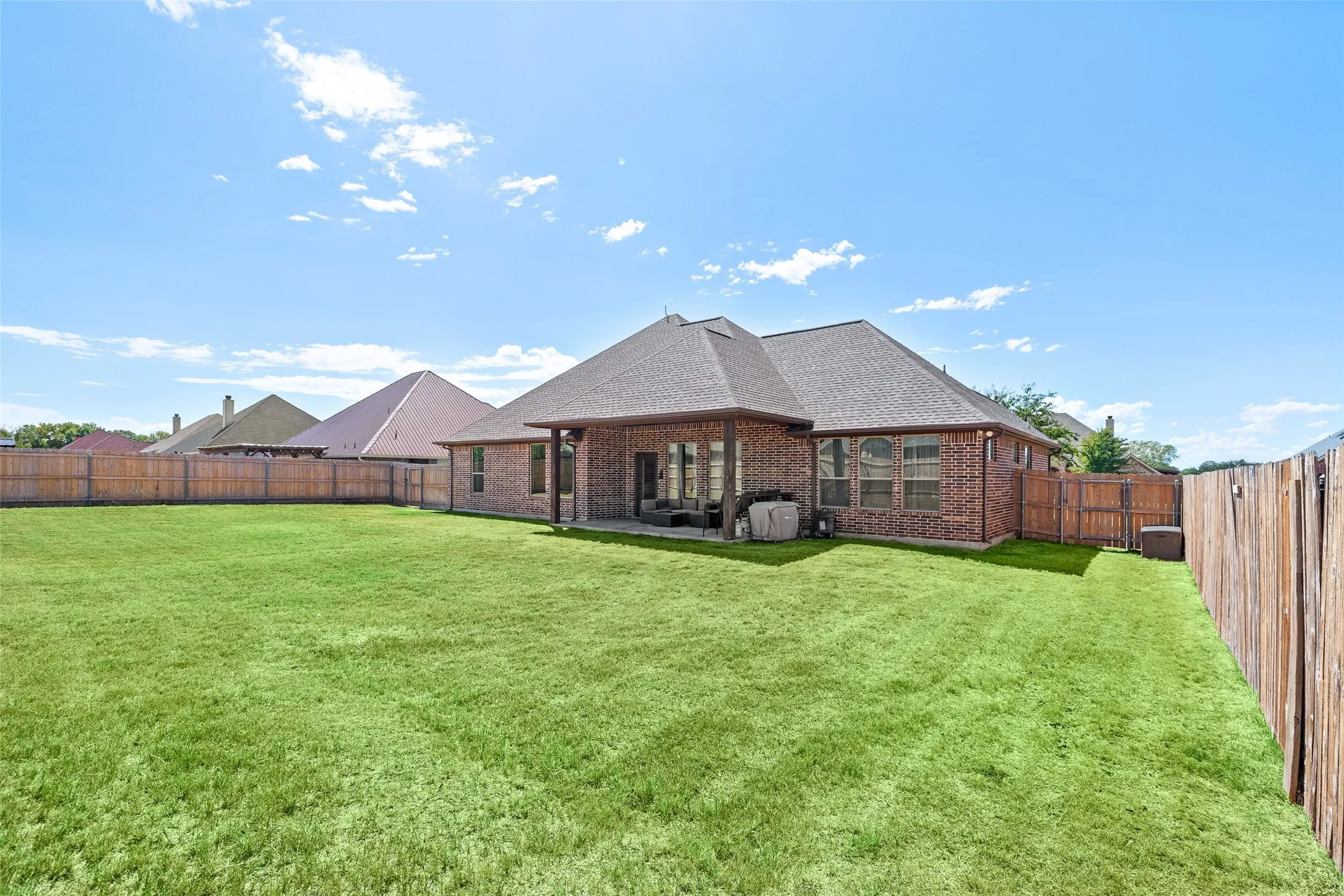 Expansive green lawn with a full privacy fence