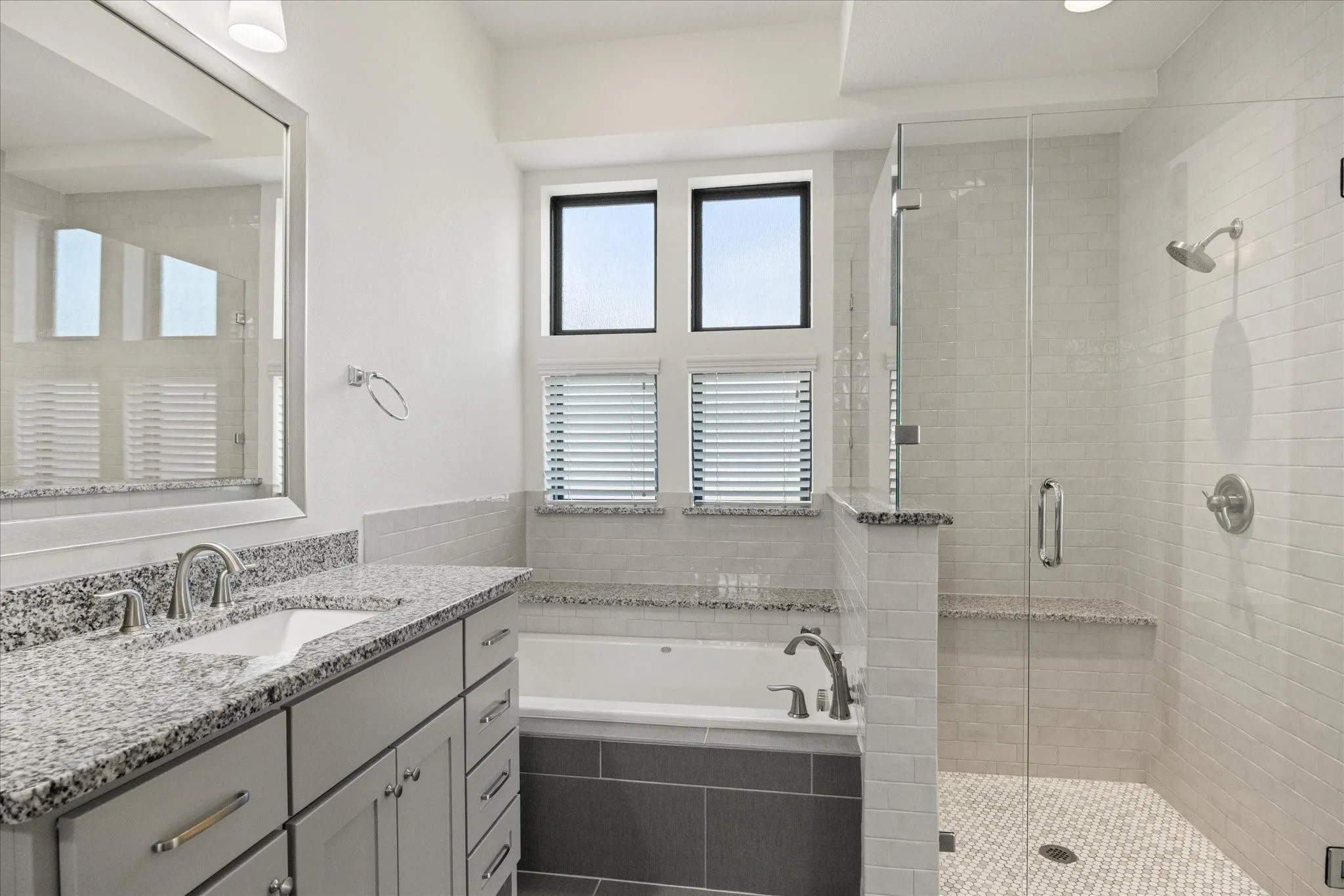 Bathroom featuring a spacious vanity with a granite countertop, undermount sink, and brushed nickel fixtures