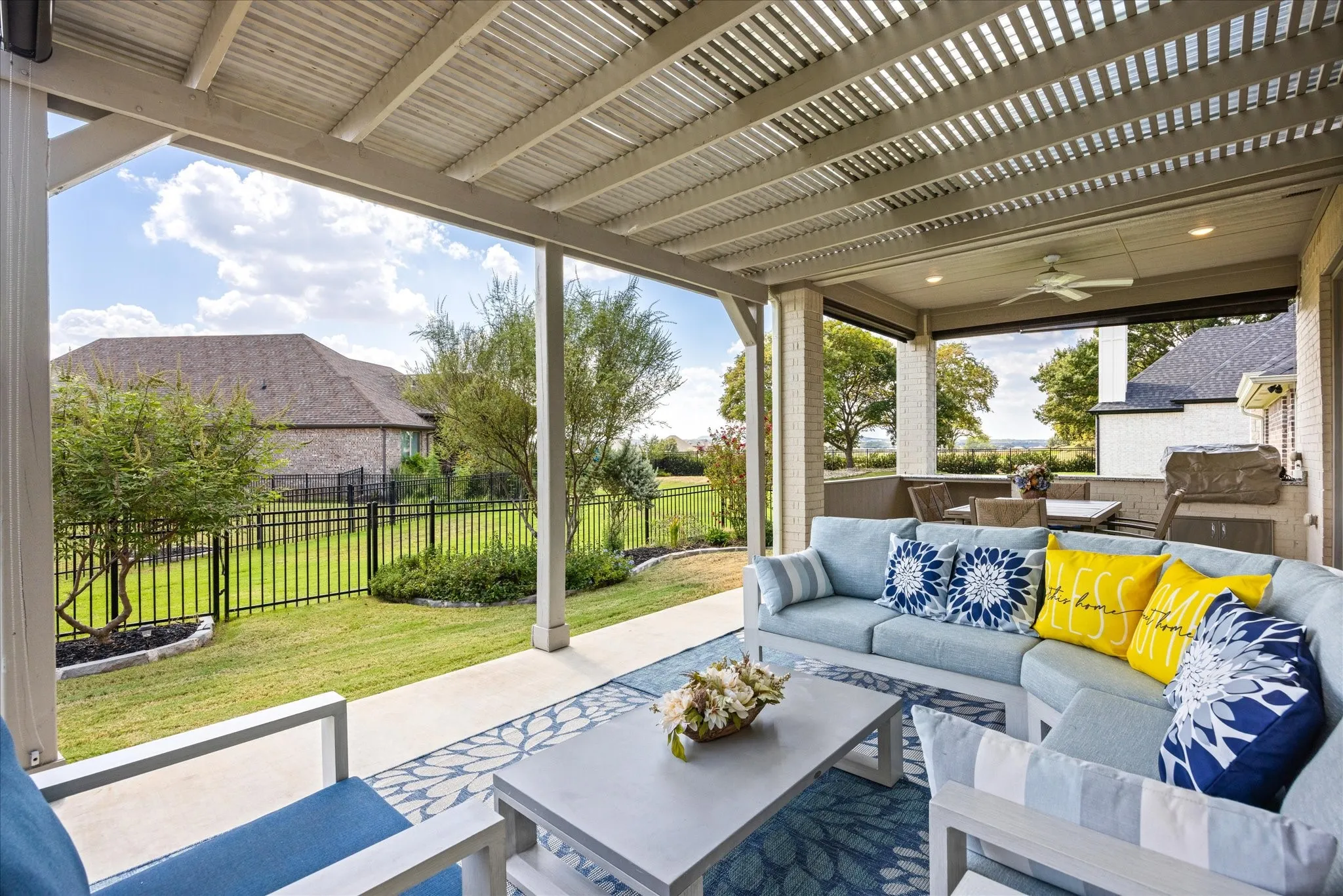 Covered patio featuring an open slatted ceiling, recessed lighting, and a ceiling fan