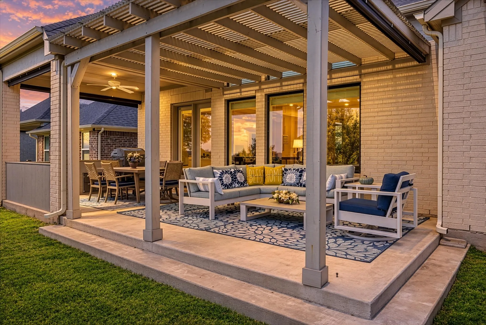 Expansive covered patio with a ceiling fan, a full-height brick exterior, and multiple large windows