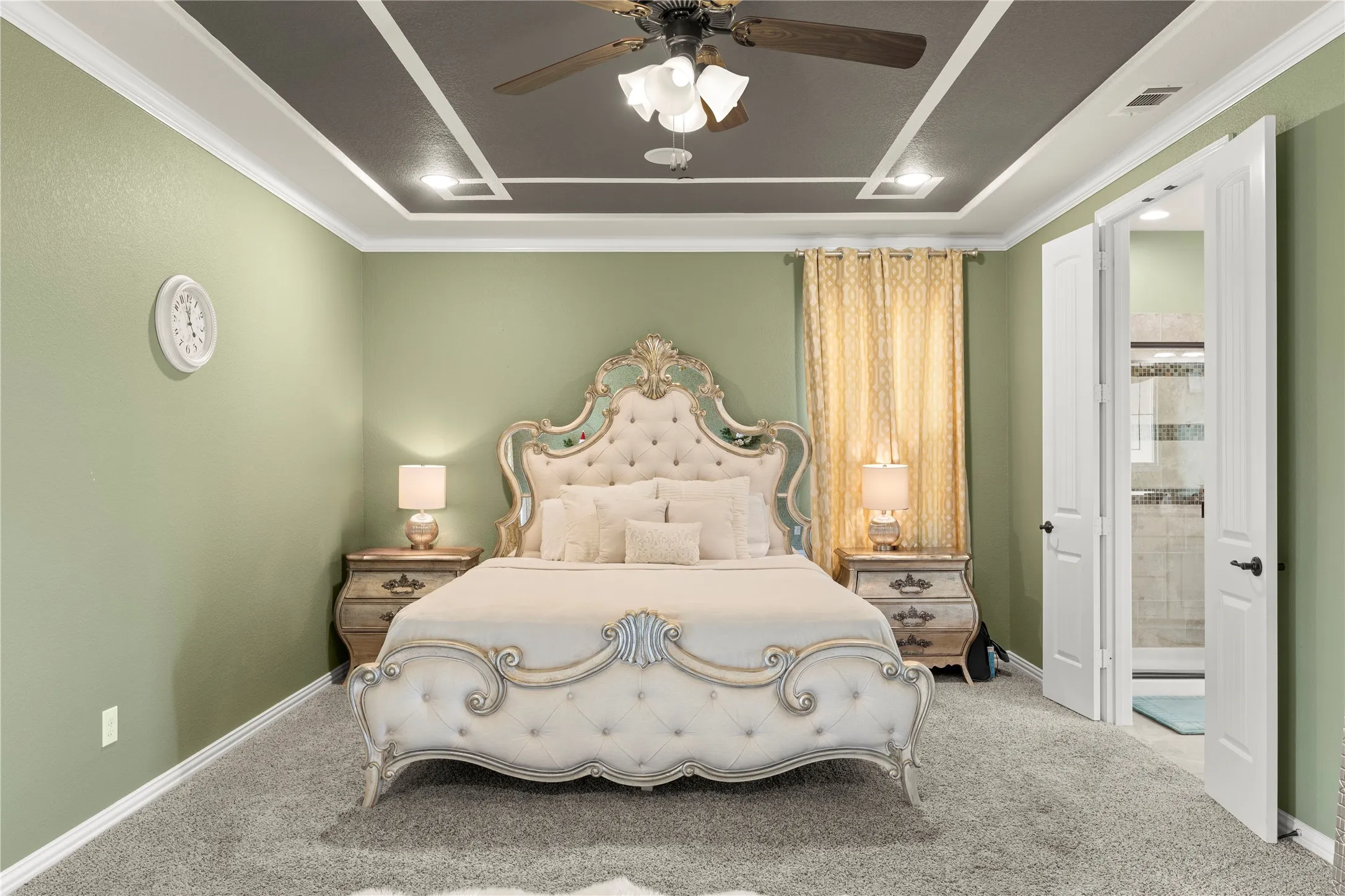 Recessed ceiling with decorative molding, ceiling fan, and light green walls