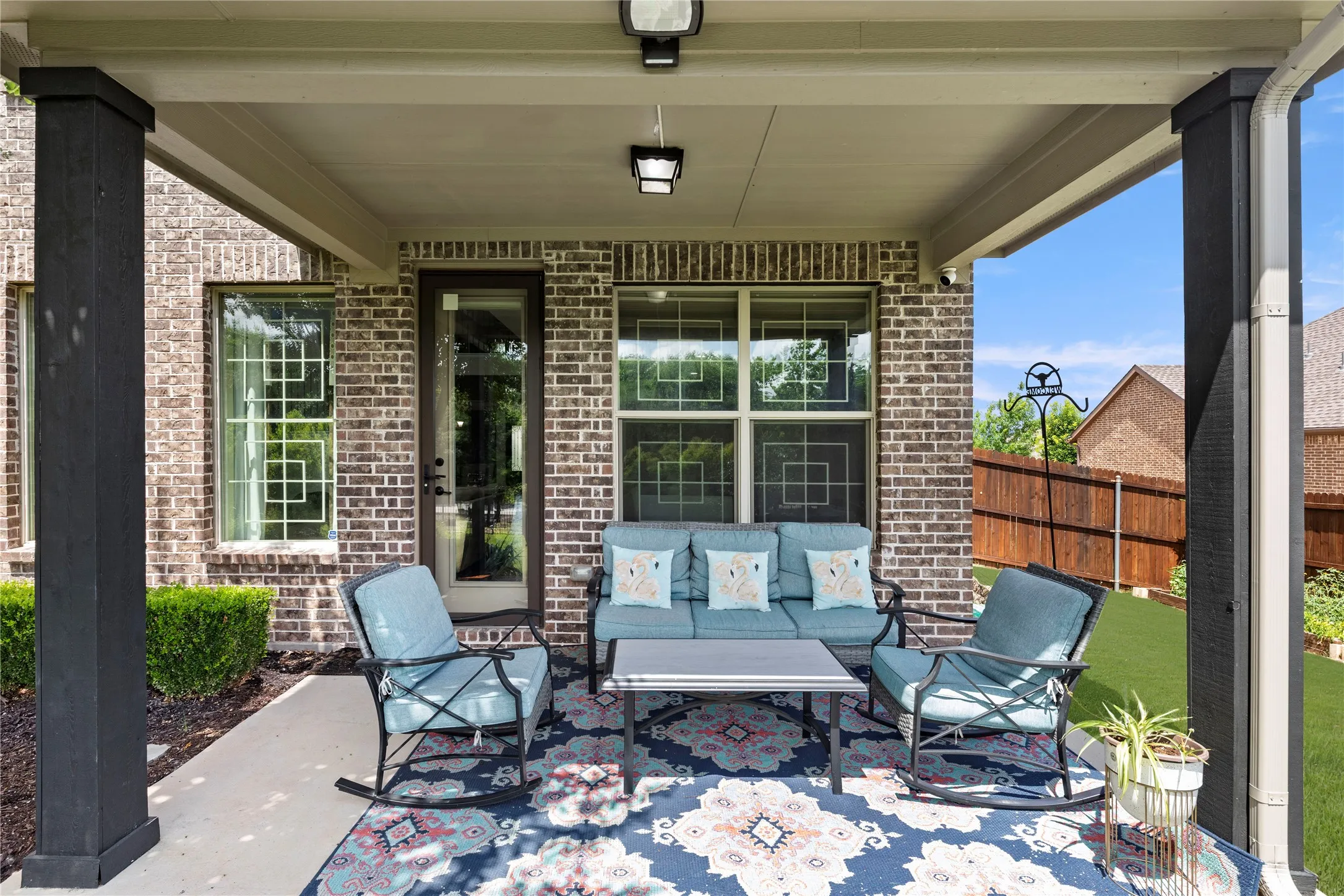Covered patio featuring a brick exterior and concrete flooring