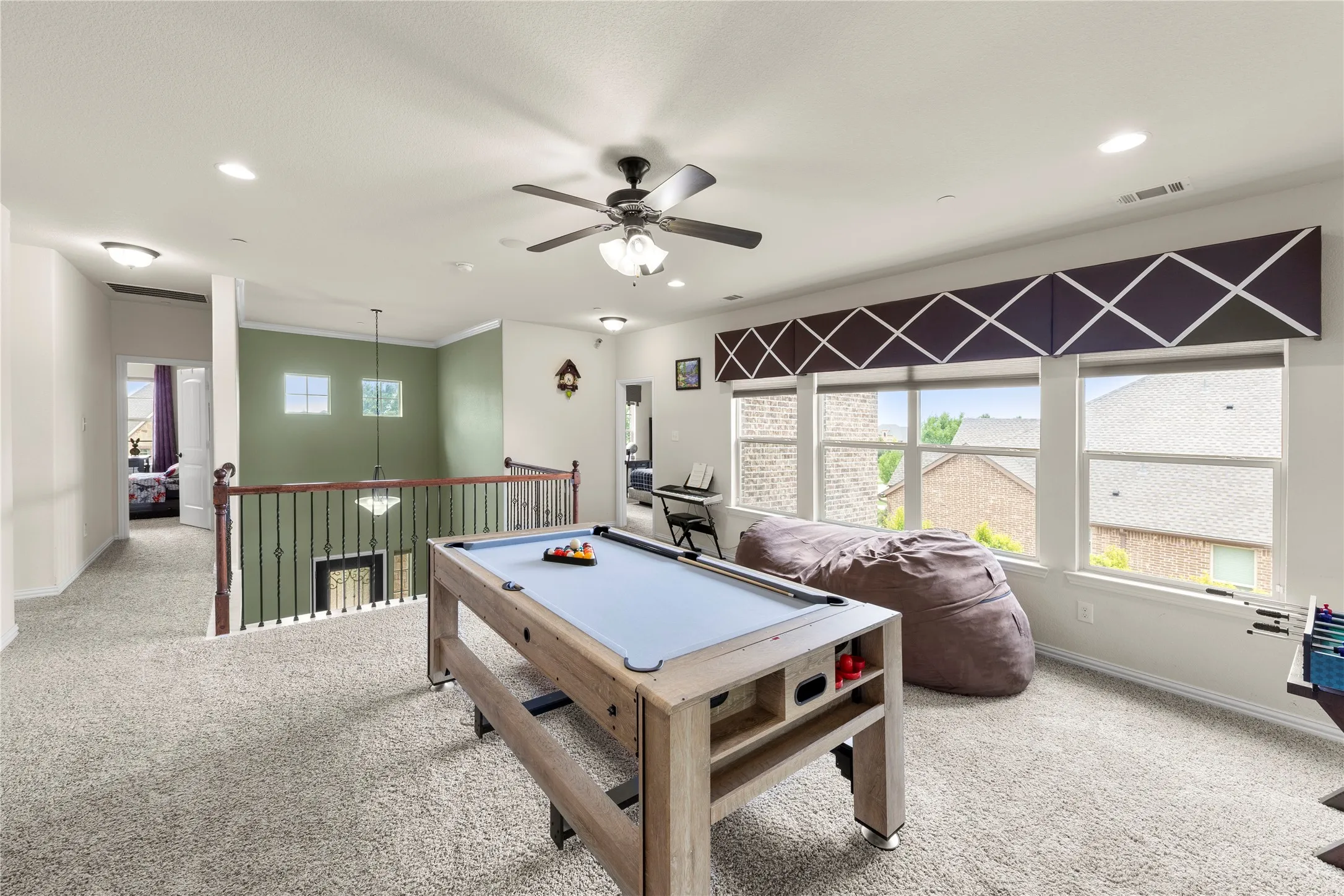 Spacious upstairs area featuring carpet flooring, recessed lighting, and a ceiling fan