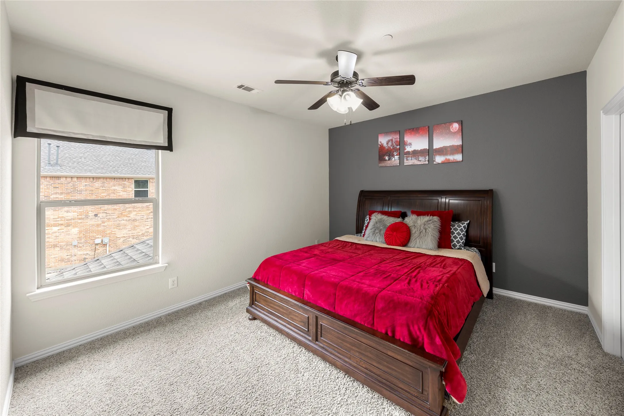 Carpeted room featuring a single window with a valance, a ceiling fan with integrated lighting, and a dark accent wall