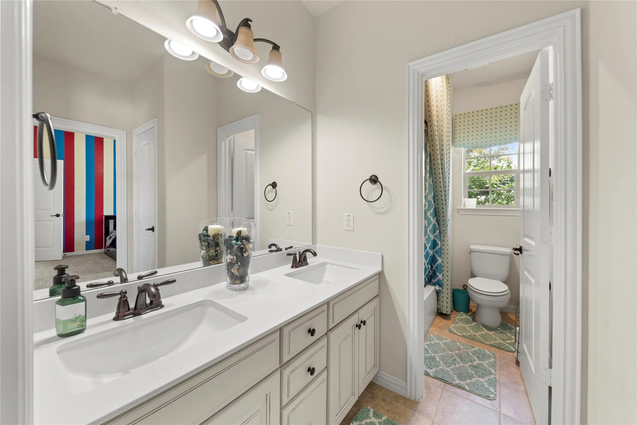 Dual sink vanity featuring white countertops and bronze-finish fixtures
