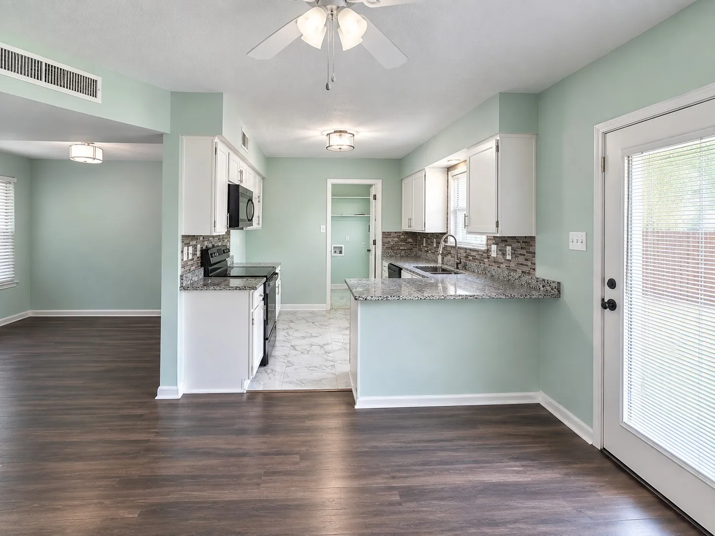 Kitchen, Breakfast, And Dining/Bonus area featuring white cabinetry, stone-finish countertops, mosaic tile backsplash, and wood-finish flooring
