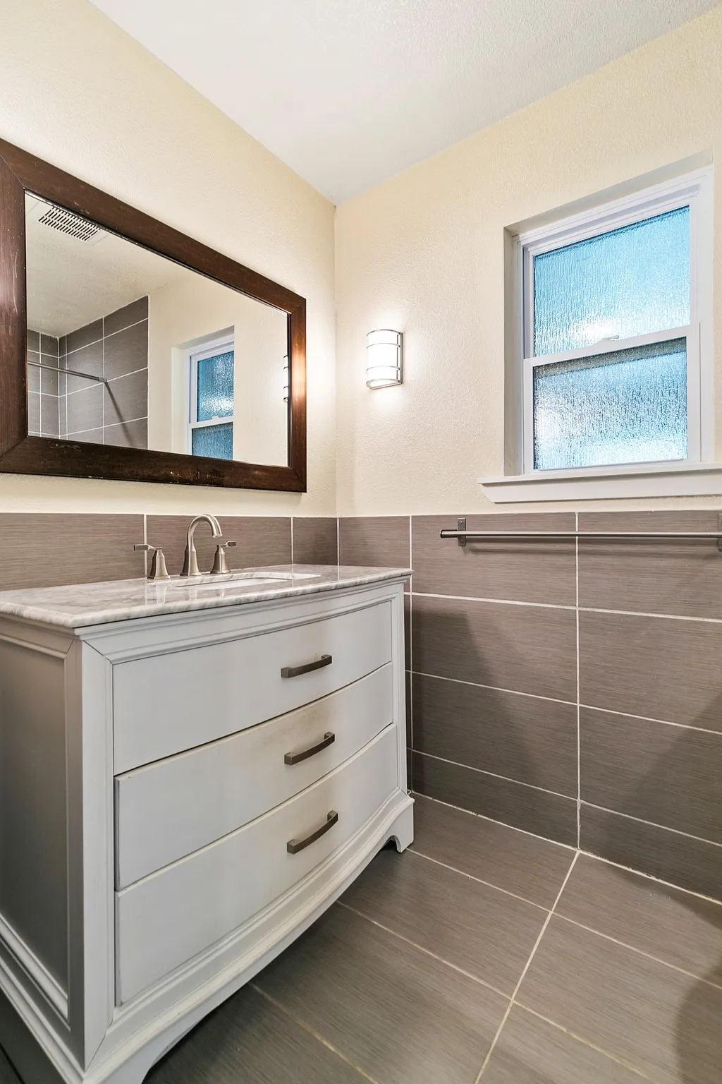 Primary bathroom. White vanity with three drawers, a stone countertop, and an undermount sink
