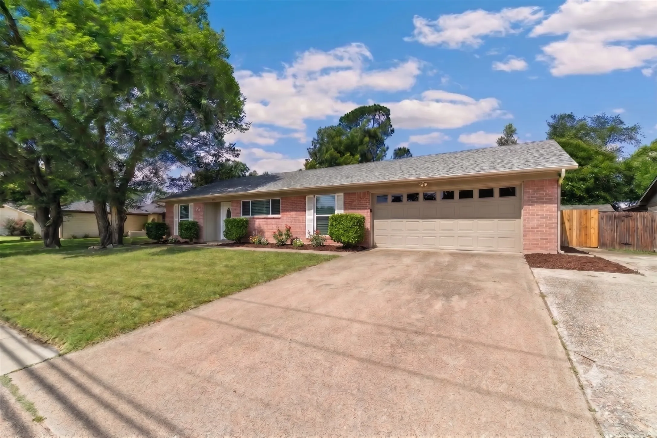 Brick exterior with a gray shingle roof and an attached two-car garage