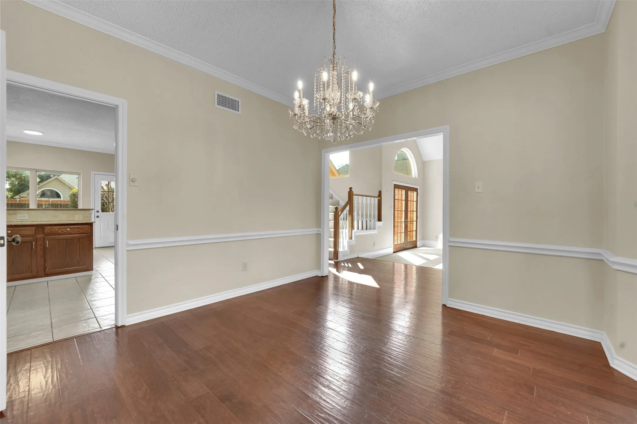 Hardwood-finish flooring, crown molding, chair rail molding, and a crystal chandelier