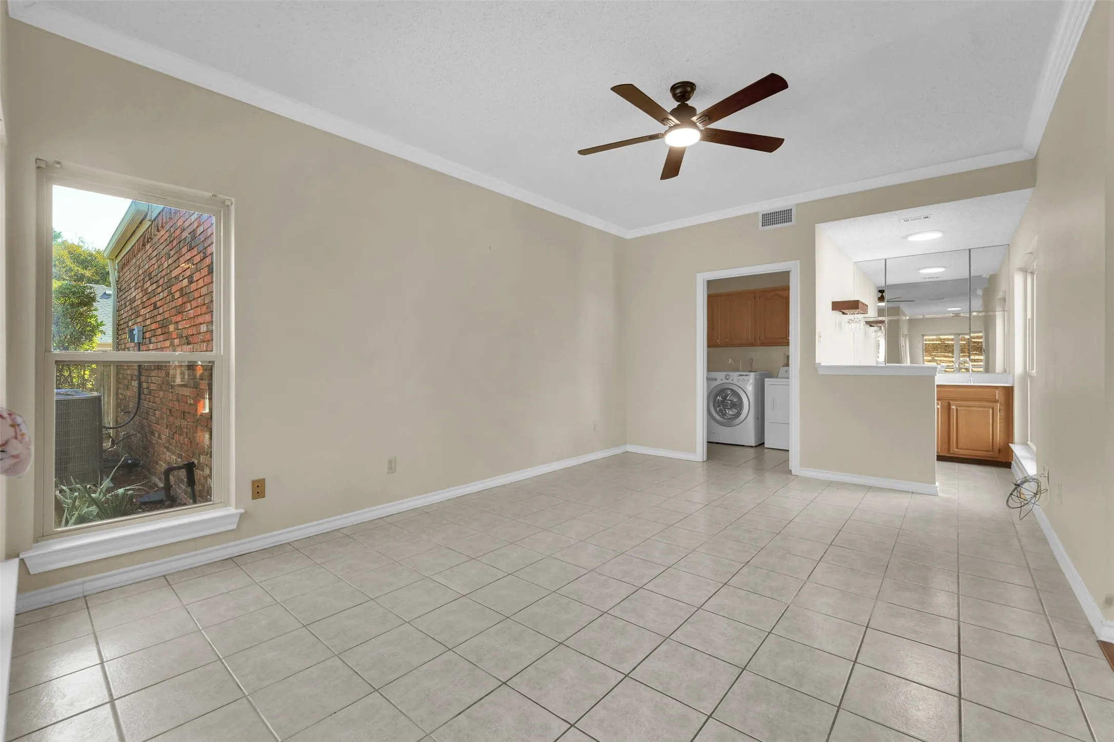 Tile flooring, ceiling fan with integrated lighting, window, built-in cabinetry, mirrored wall