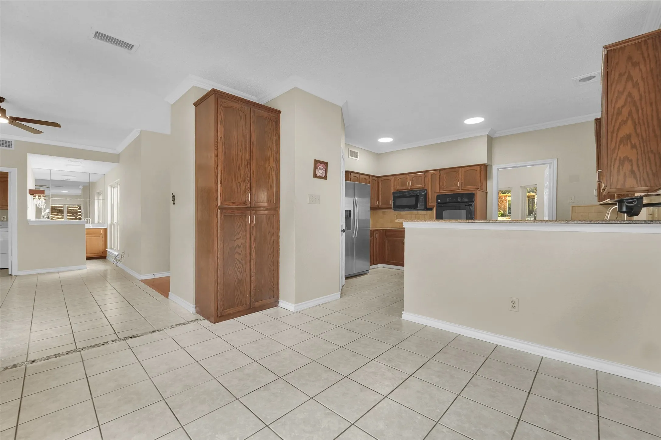Tiled flooring throughout, recessed lighting, and a built-in pantry