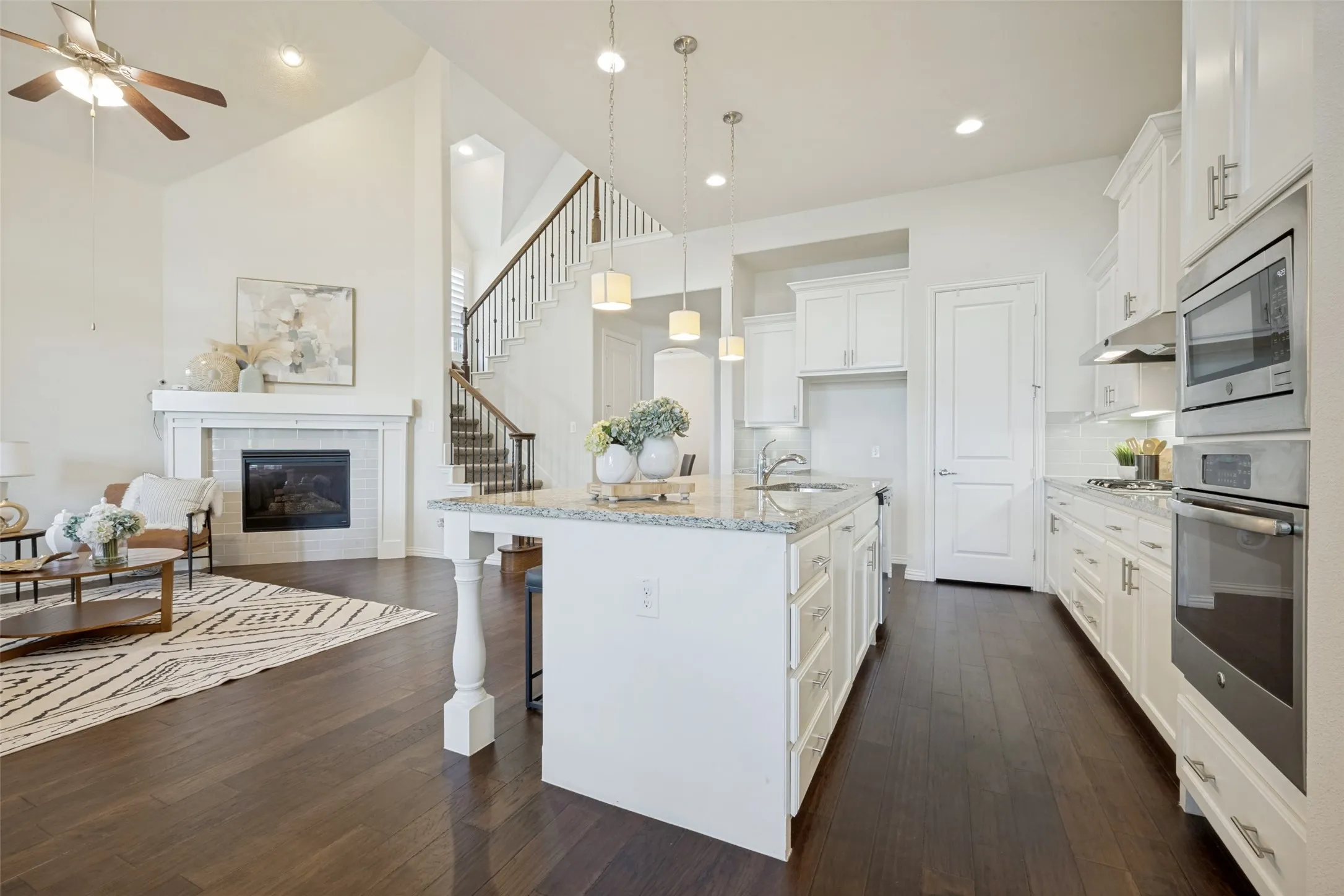 Gourmet kitchen with white cabinetry, stainless steel appliances, and a central island with a sink