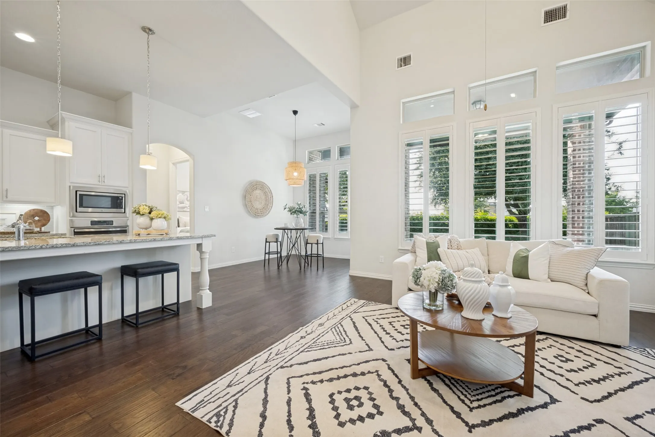Open-concept living area featuring a vaulted ceiling and dark wood-finish flooring