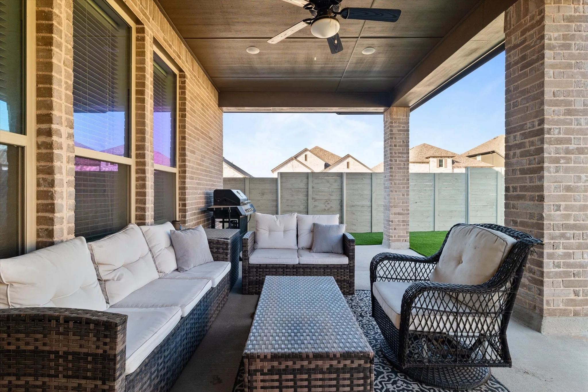 Covered patio featuring a ceiling fan, recessed lighting, and brick columns