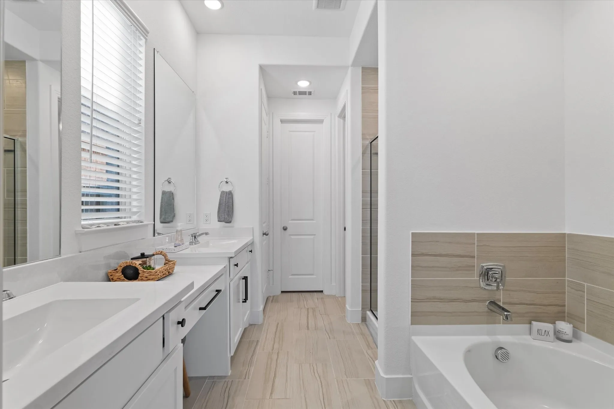Dual vanity with undermount sinks, white cabinetry, and contemporary black hardware