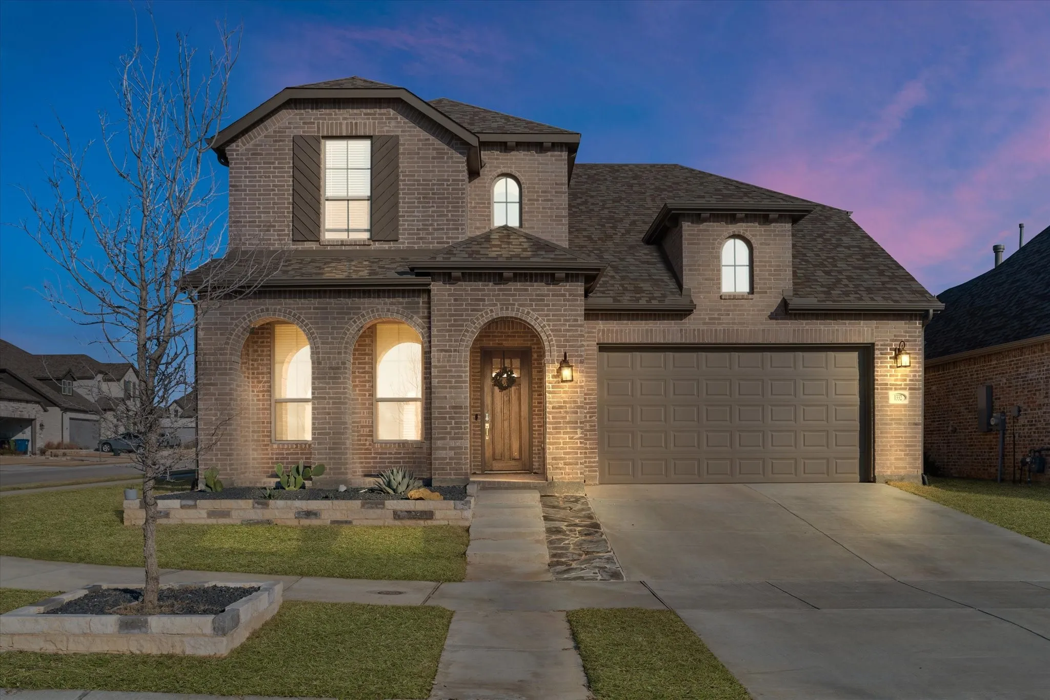 Brick exterior with arched entryways, gabled rooflines, and decorative shutters