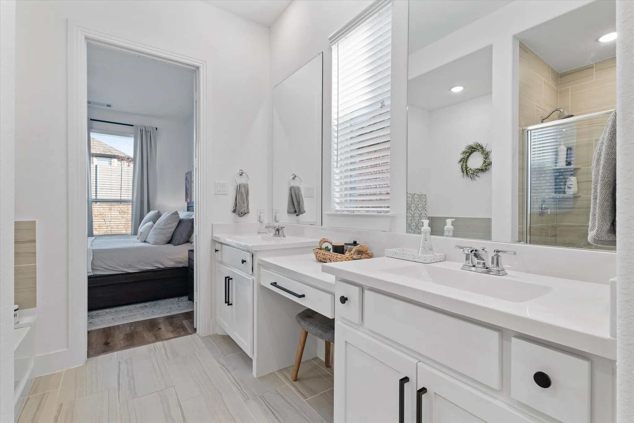 Dual vanity with integrated sinks, white cabinetry, chrome fixtures, and a framed mirror