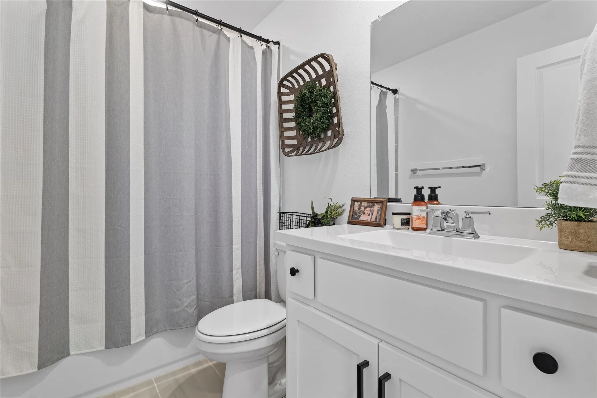 White vanity with recessed paneling and matte black hardware