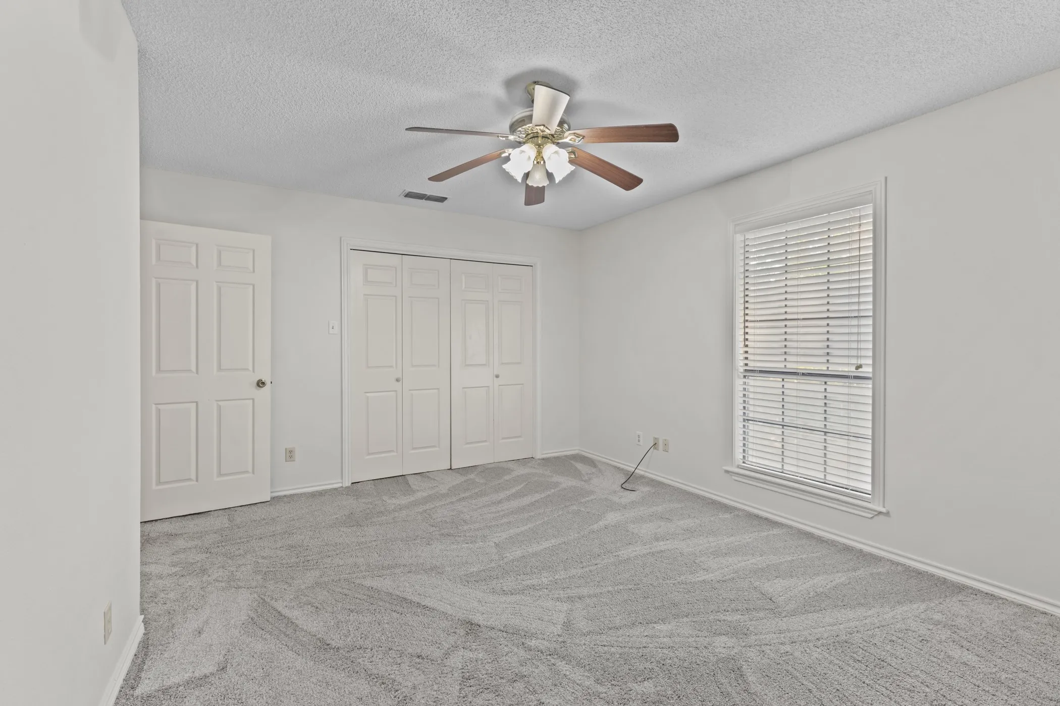 Neutral-toned walls complement the textured gray carpeting