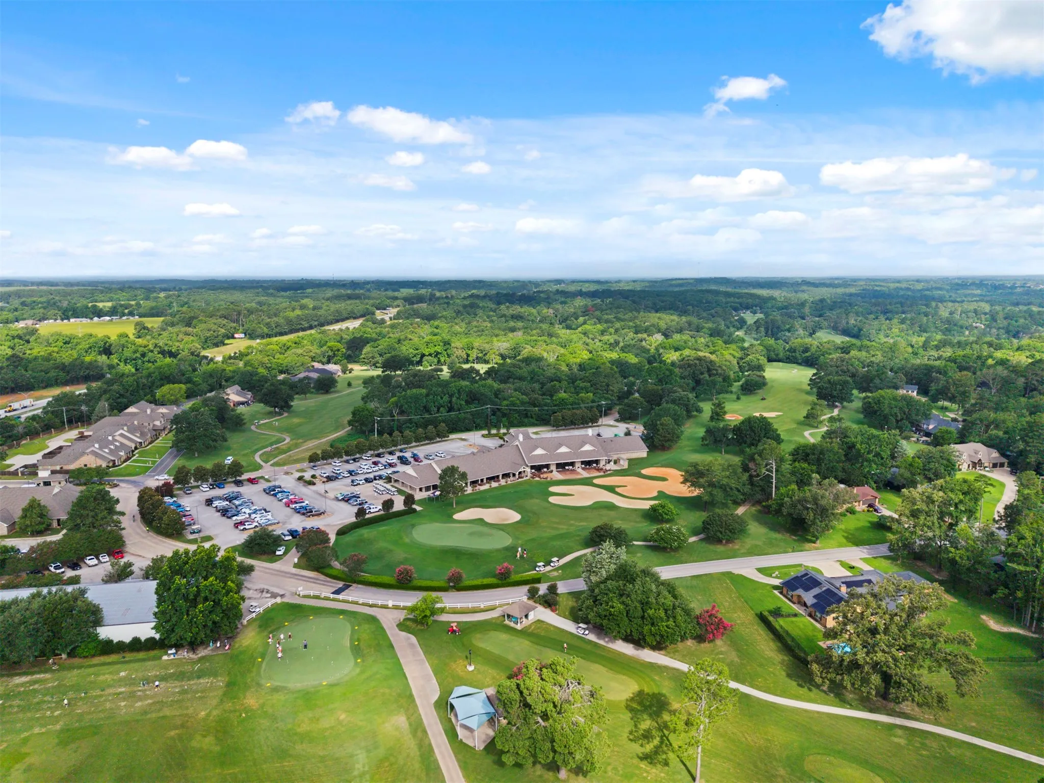 Expansive golf course setting featuring manicured greens and sand traps