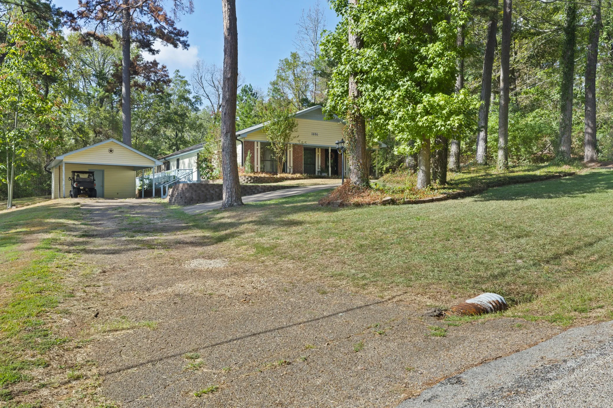 Property featuring mature trees and a detached garage with a covered carport