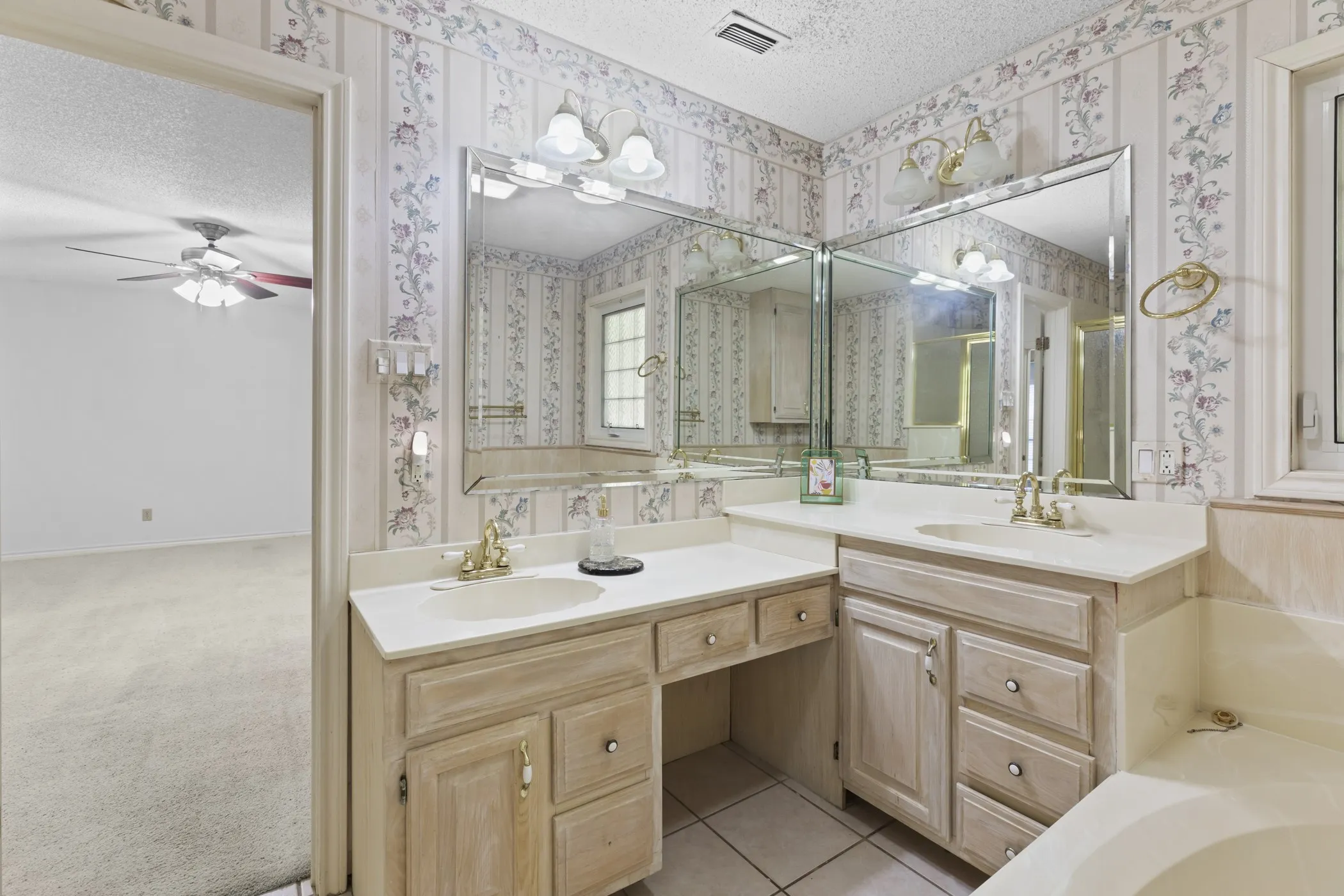 Dual vanity with integrated sinks and ample countertop space, complemented by a built-in makeup vanity