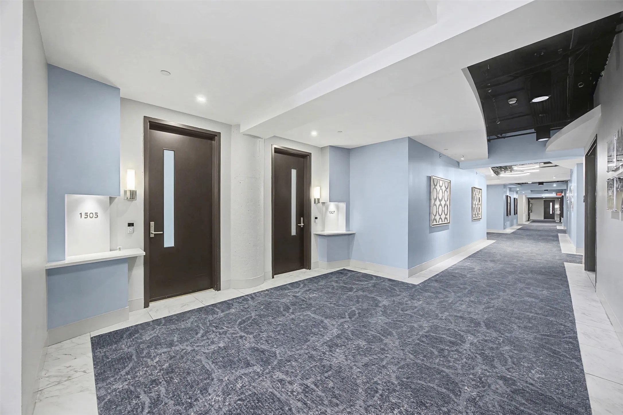 Hall featuring elevator, light marble finish flooring, and recessed lighting