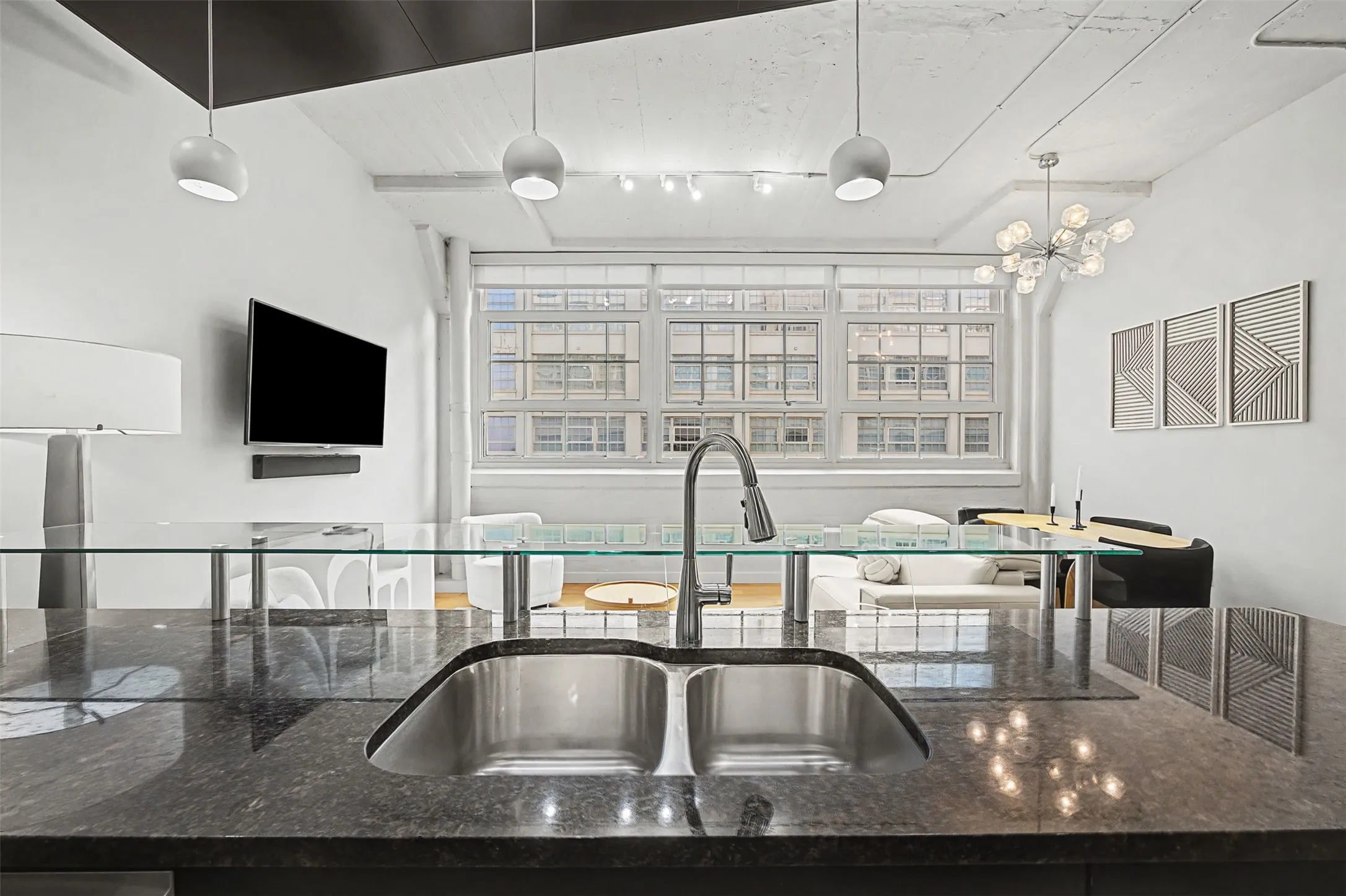 Kitchen featuring dark stone counters, healthy amount of natural light, and pendant lighting