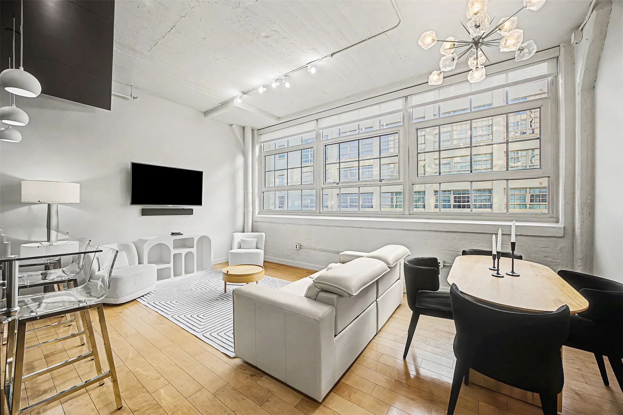 Living room featuring wood-type flooring and suspended lighting