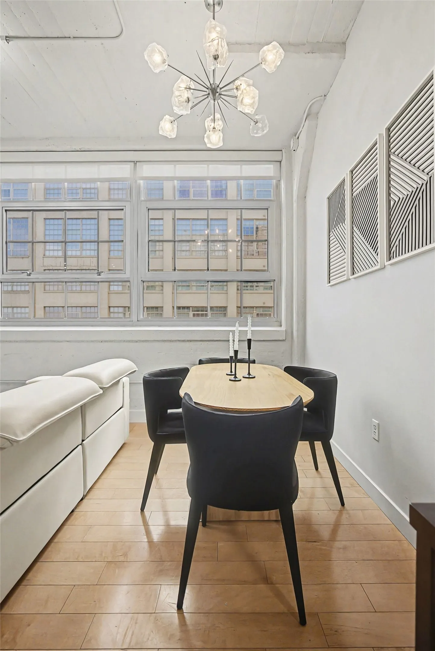 Dining room with light wood-type flooring and suspended lighting